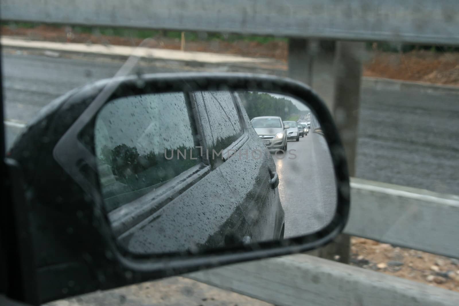 All machines in the side mirror of a car, rainy day, Russia