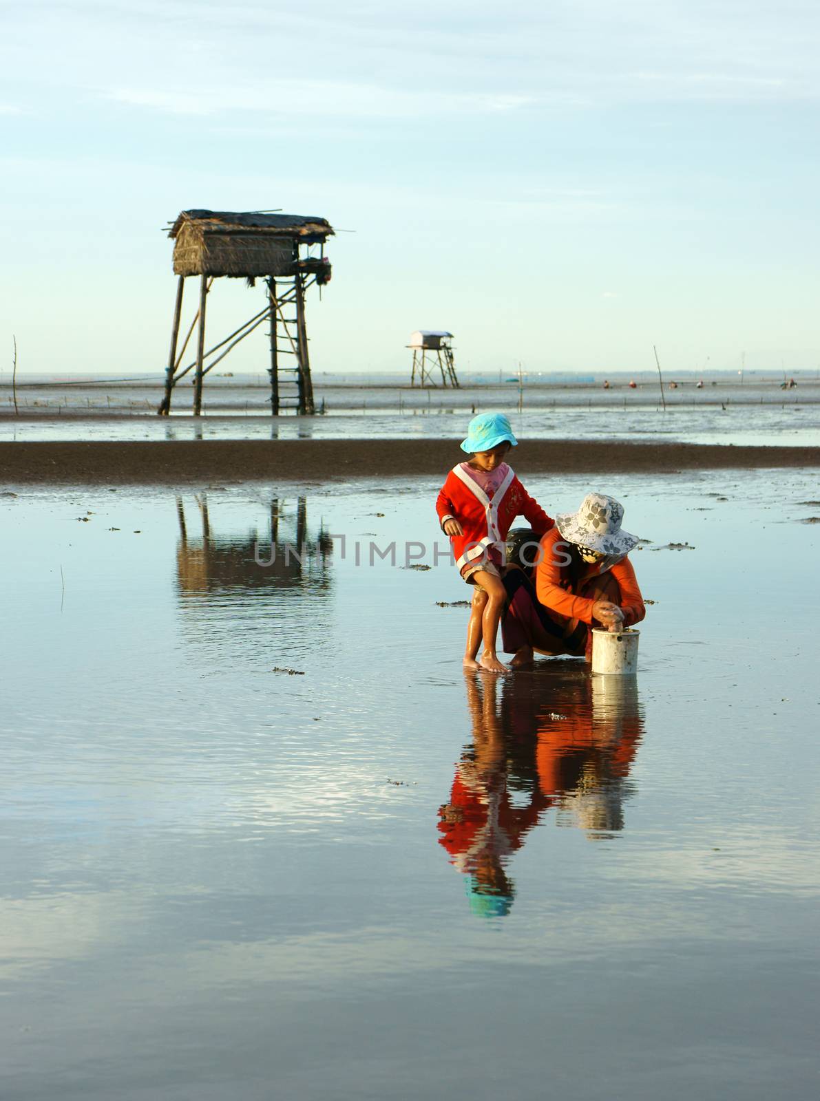 children, mother reflect on water by xuanhuongho