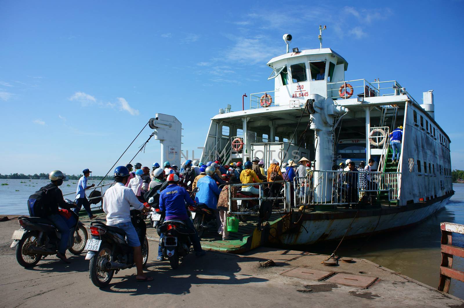 MEKONG DELTA, VIETNAM- JULY 7: Crowd of people wear heltmet sitting on motorbike to cross the river by ferry boat, this is  passenger transport vehicle on water at My Loi ferry, Viet Nam, July 7, 2014