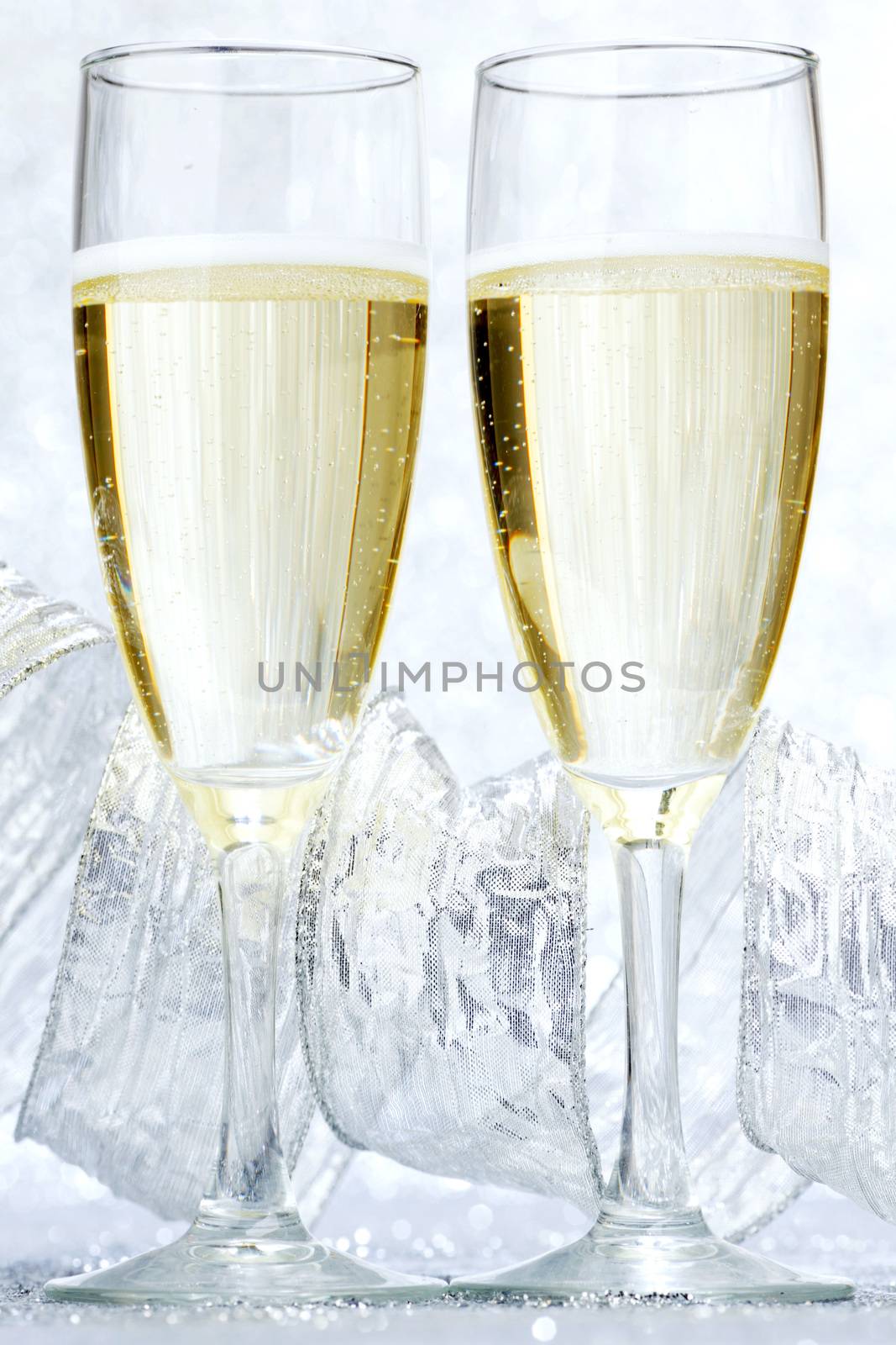 Two glasses of champagne with bow on silver background