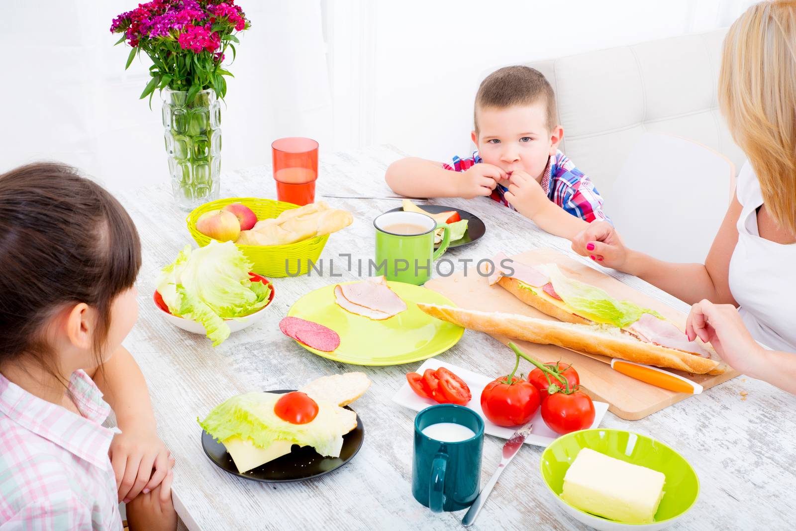 Happy family having breakfast at home by Spectral