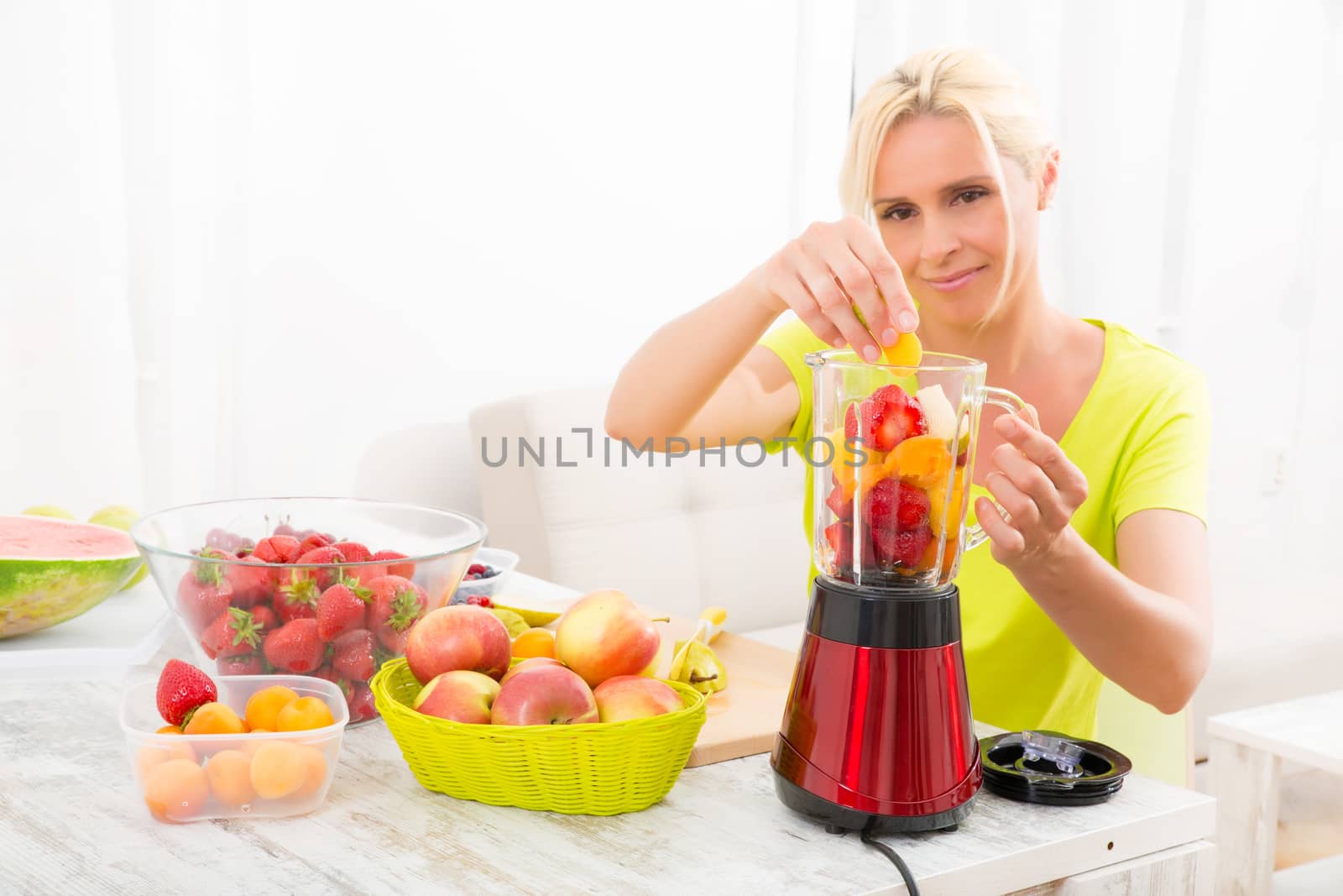 Mature woman blending a smoothie					 by Spectral