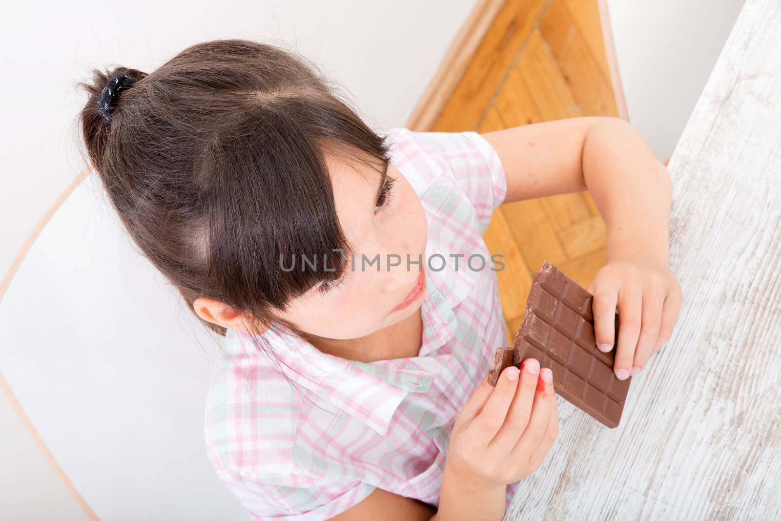 Daughter eating chocolate at home	 by Spectral