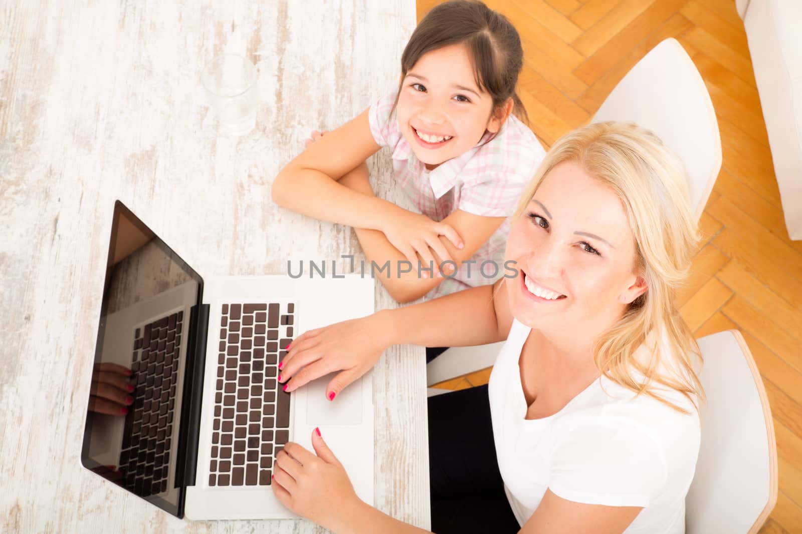A mother with her daughter looking at a Laptop at home.
