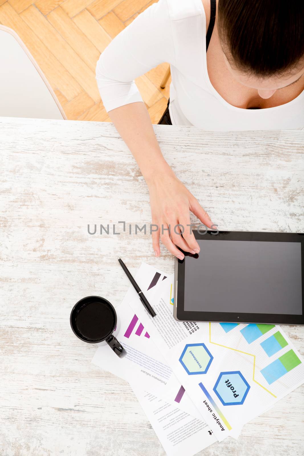 A young adult woman developing a business plan with her tablet PC at home.
