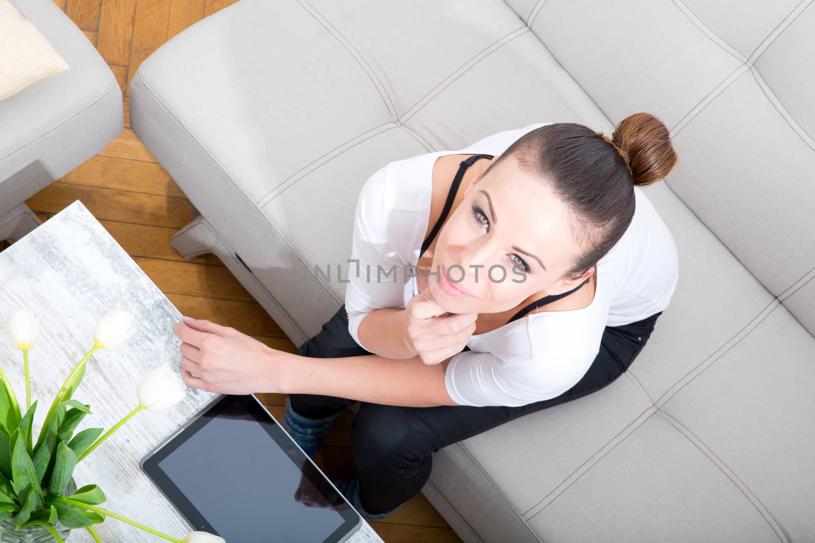 A young woman with a tablet pc on the sofa.