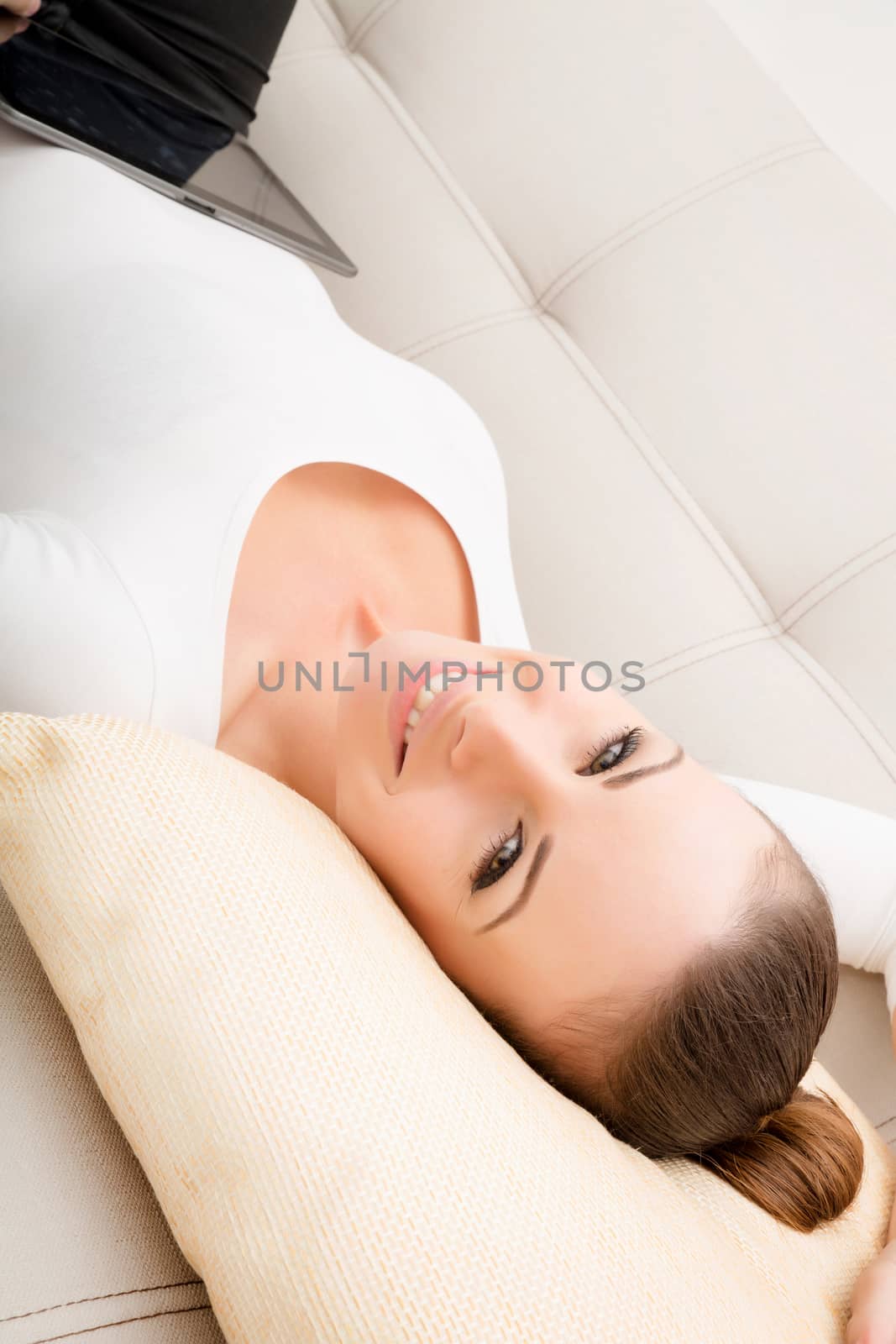 Young woman with a Tablet PC on the Sofa by Spectral