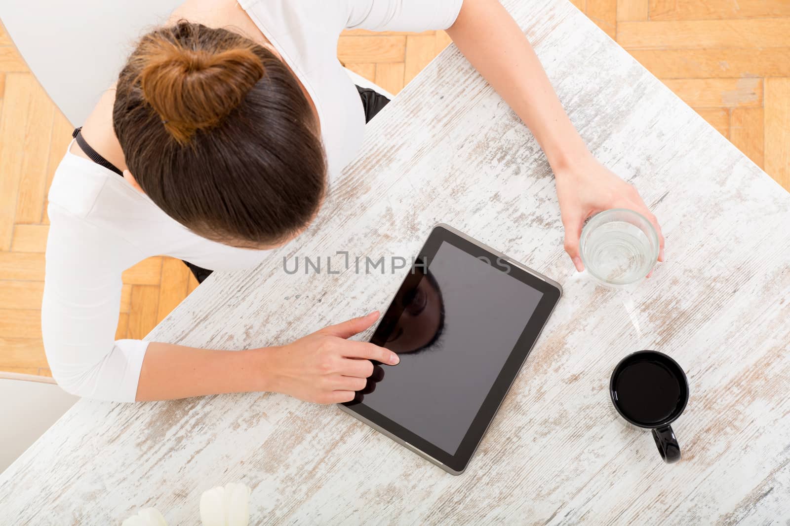 A young adult woman seen from above with tablet.
