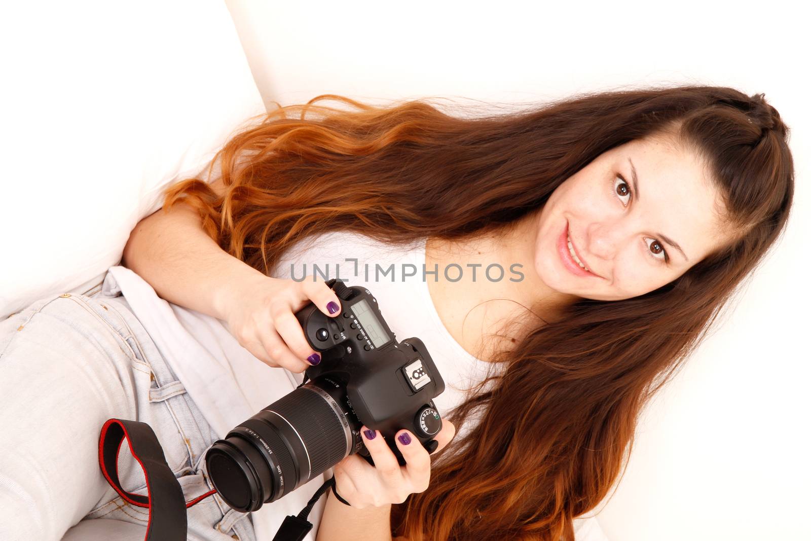 A young hispanic girl with DSLR camera in the bed. 
