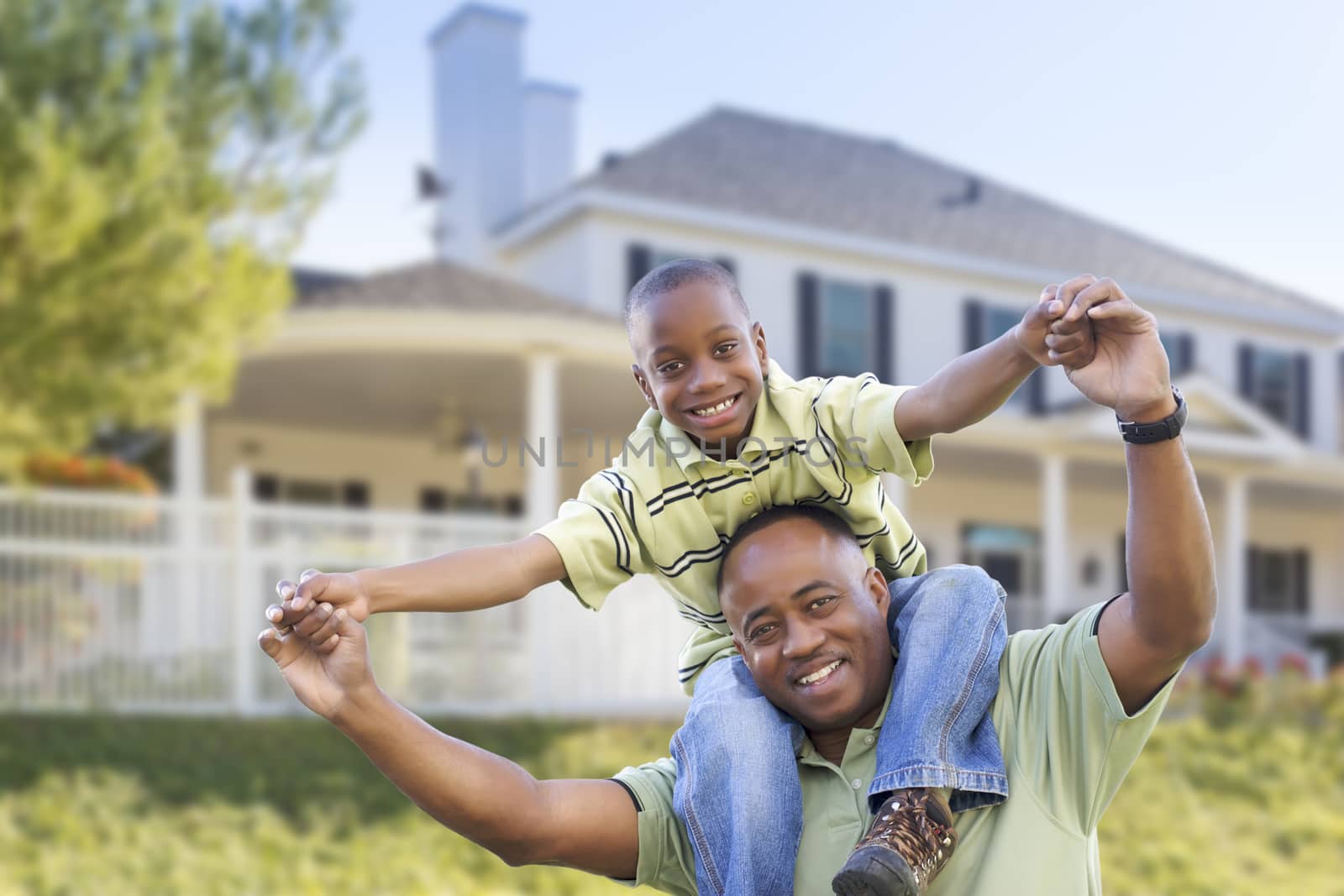 Playful African American Father and Son In Front Yard of Home.