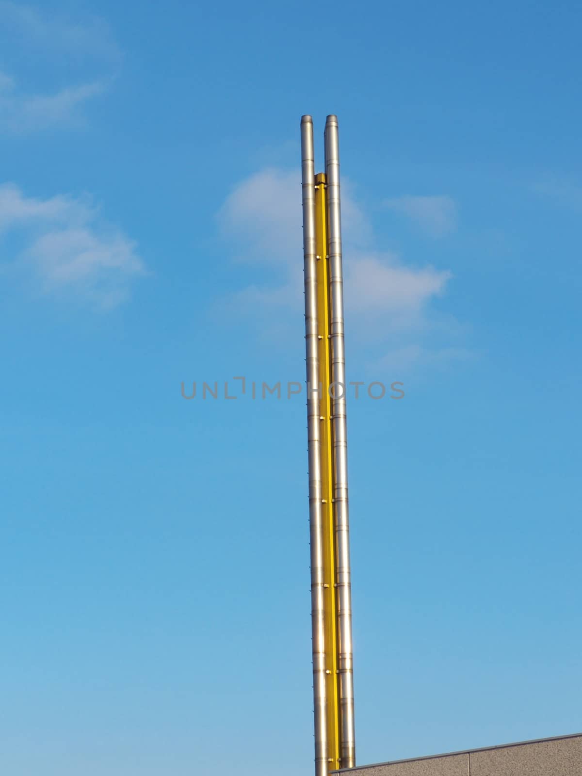 Chimney, flue pipe of a factory against a blue sky
