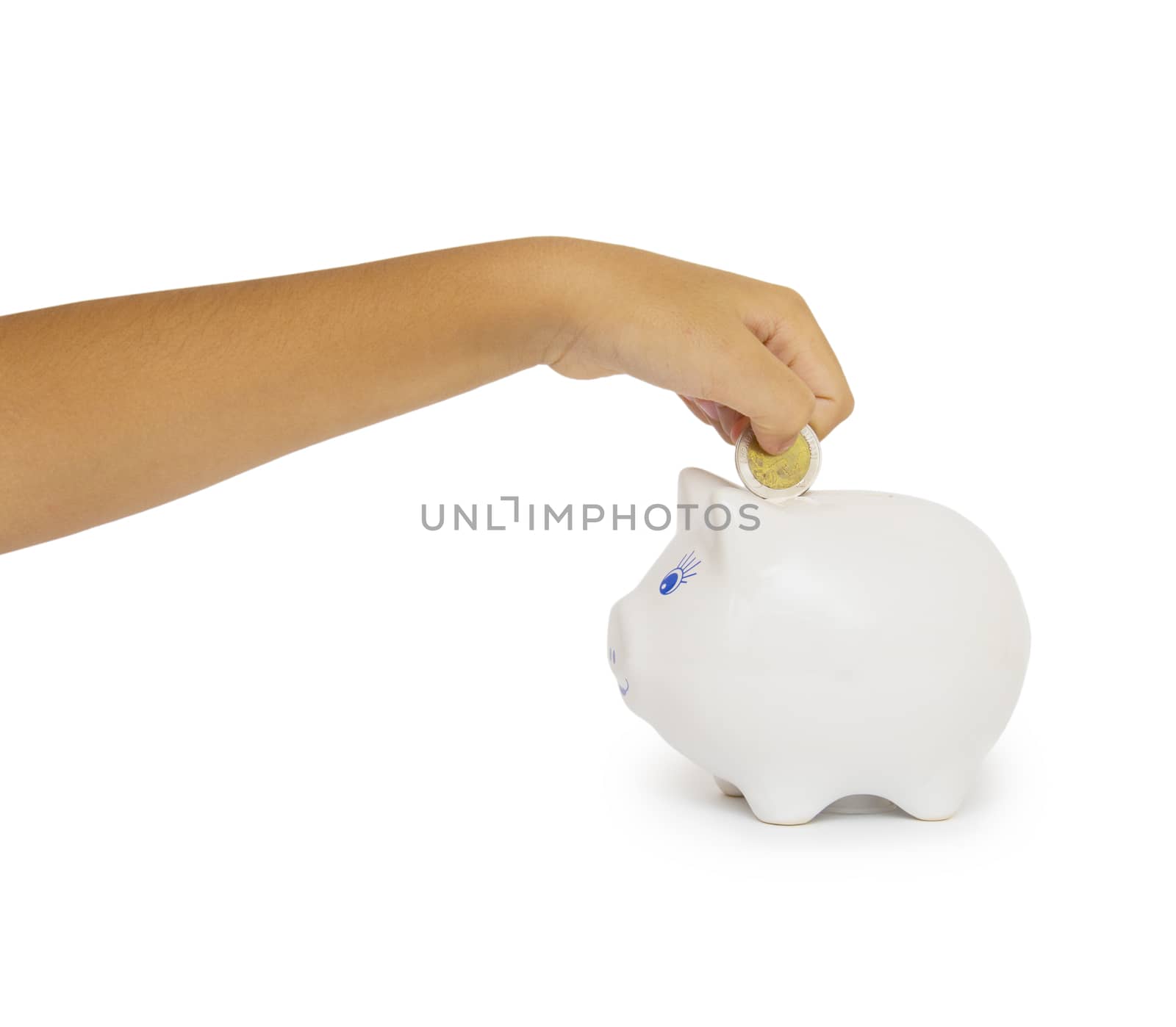 hand putting coin into a piggy bank isolated on white