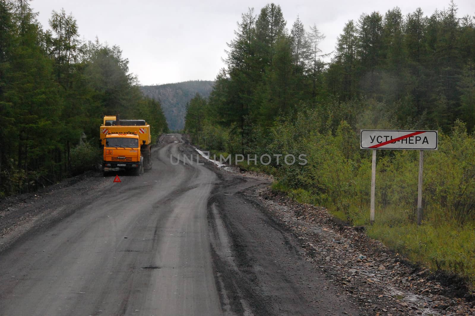 Town name metal plate and truck at gravel road by danemo