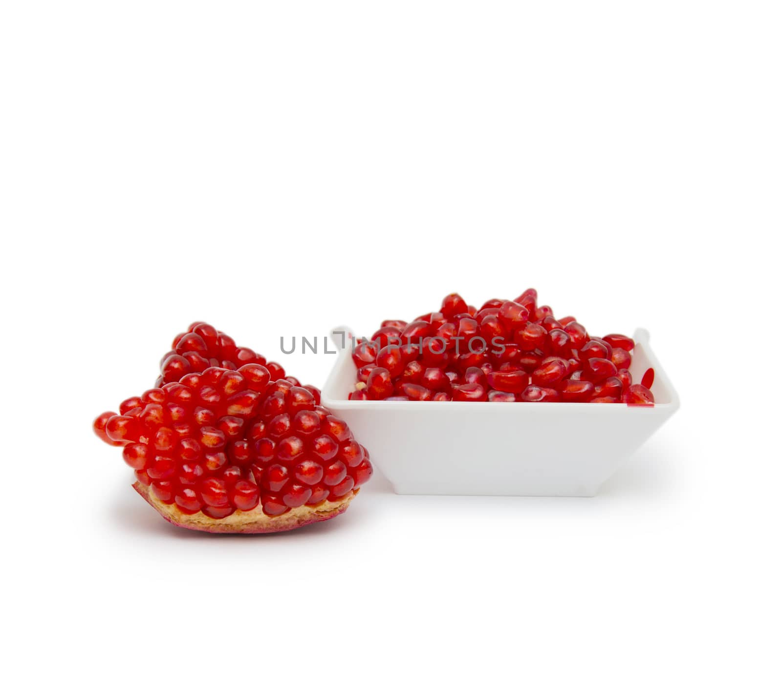 Loose pomegranate seeds in a white bowl by cocoo