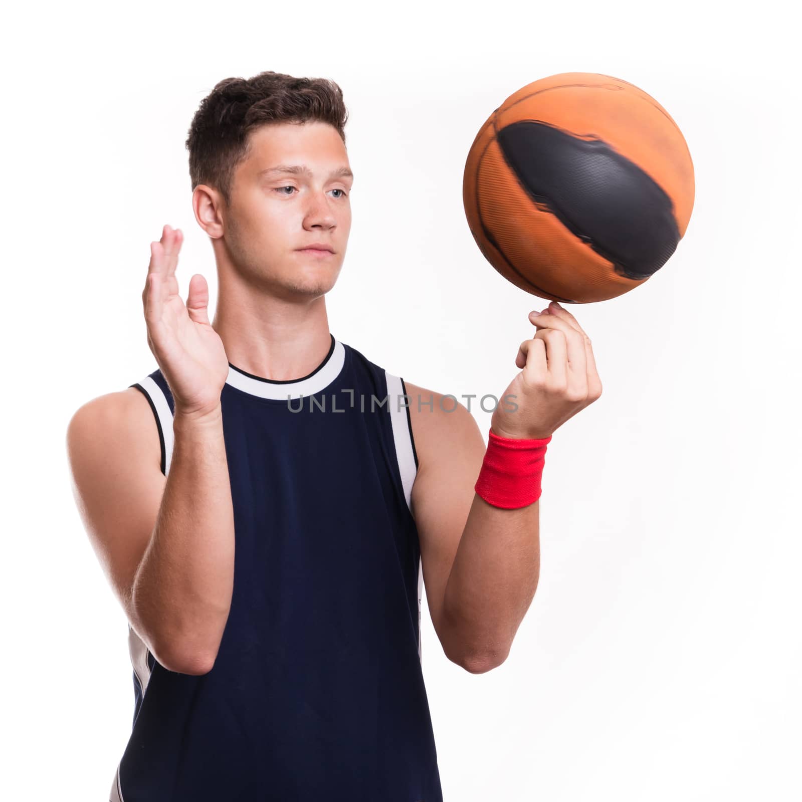 Basketball player spins the ball on his finger - studio shoot 