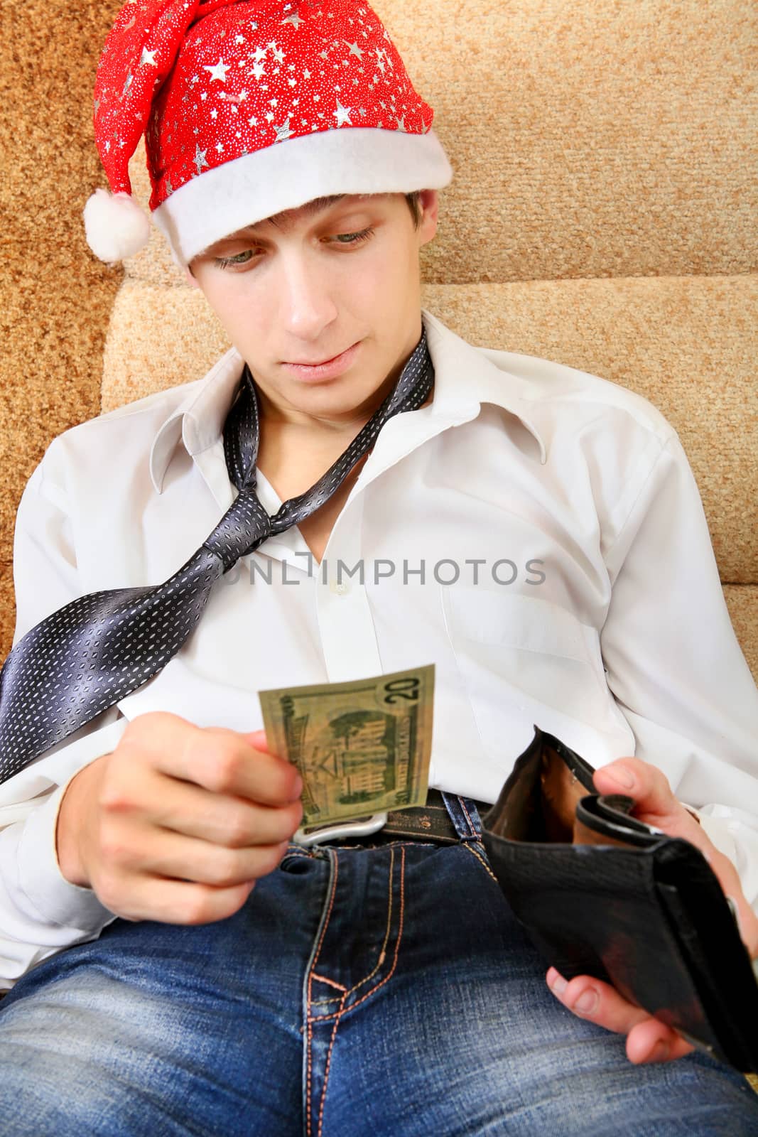 Teenager in Santa Hat Checking the Wallet on the Sofa at the Home