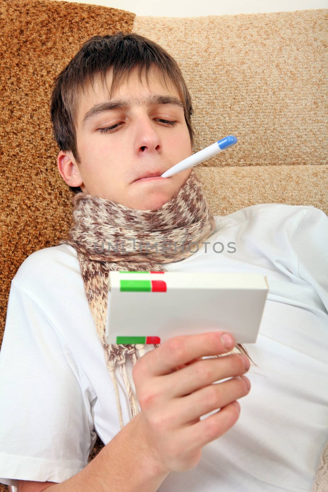 Sick Teenager with Thermometer and Drug on the Sofa at the Home