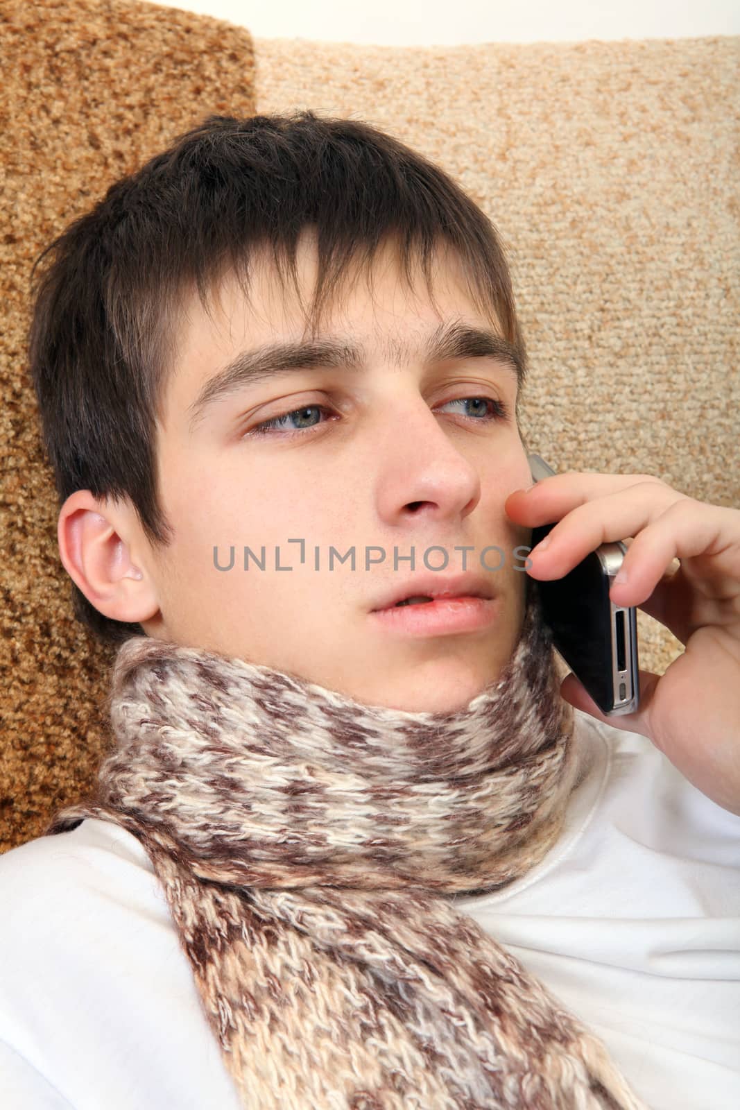 Sick Teenager with Cellphone on the Sofa at the Home