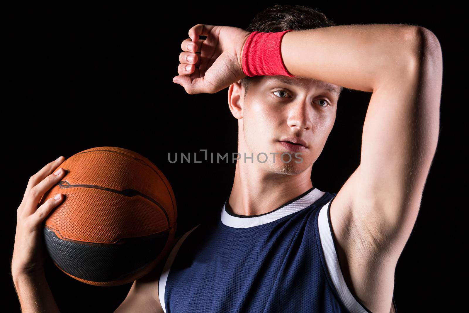 Basketball player wipes the sweat from his forehead - studio shoot 