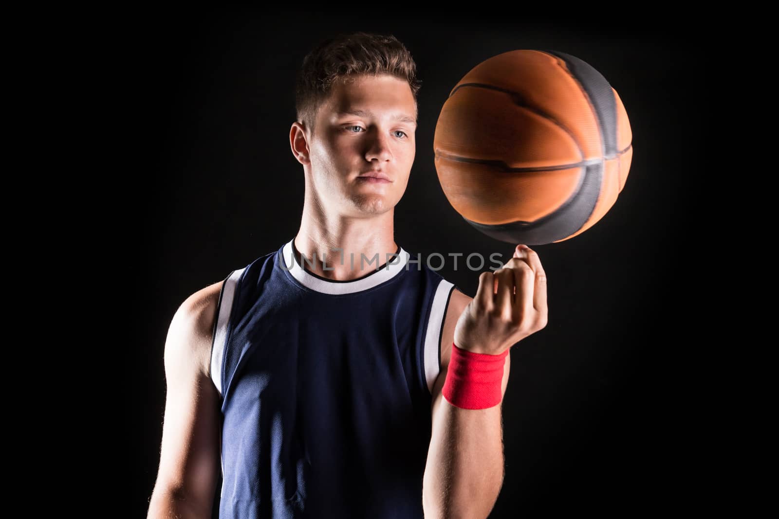 Basketball player spinning ball on finger - studio shoot 