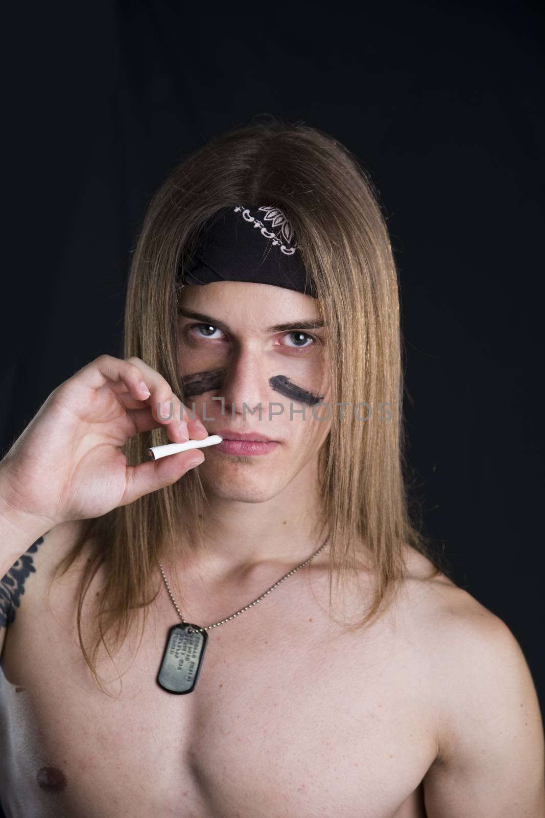 Shirtless male model wearing a bandanna smoking a cigarette