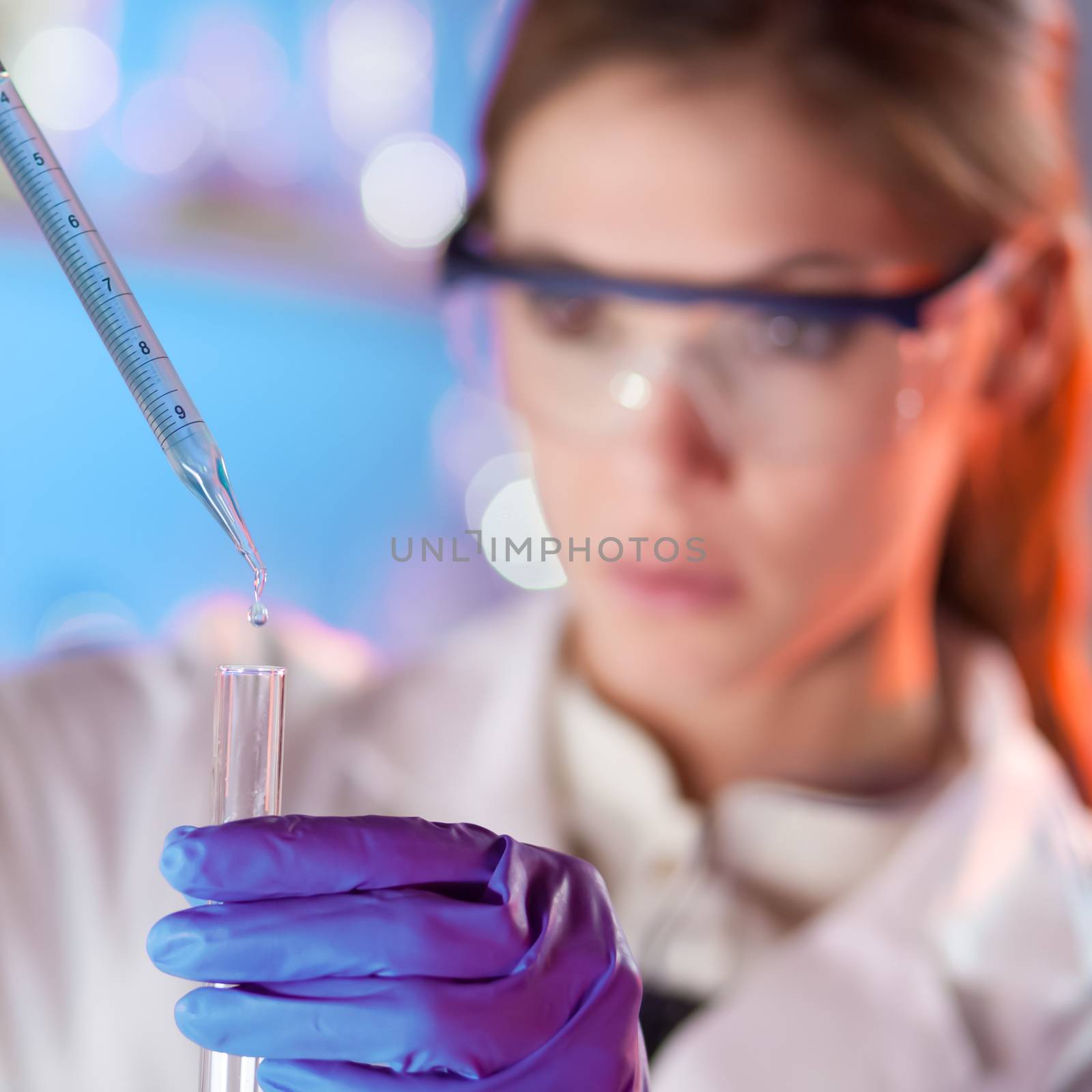 Young scientist pipetting. by kasto