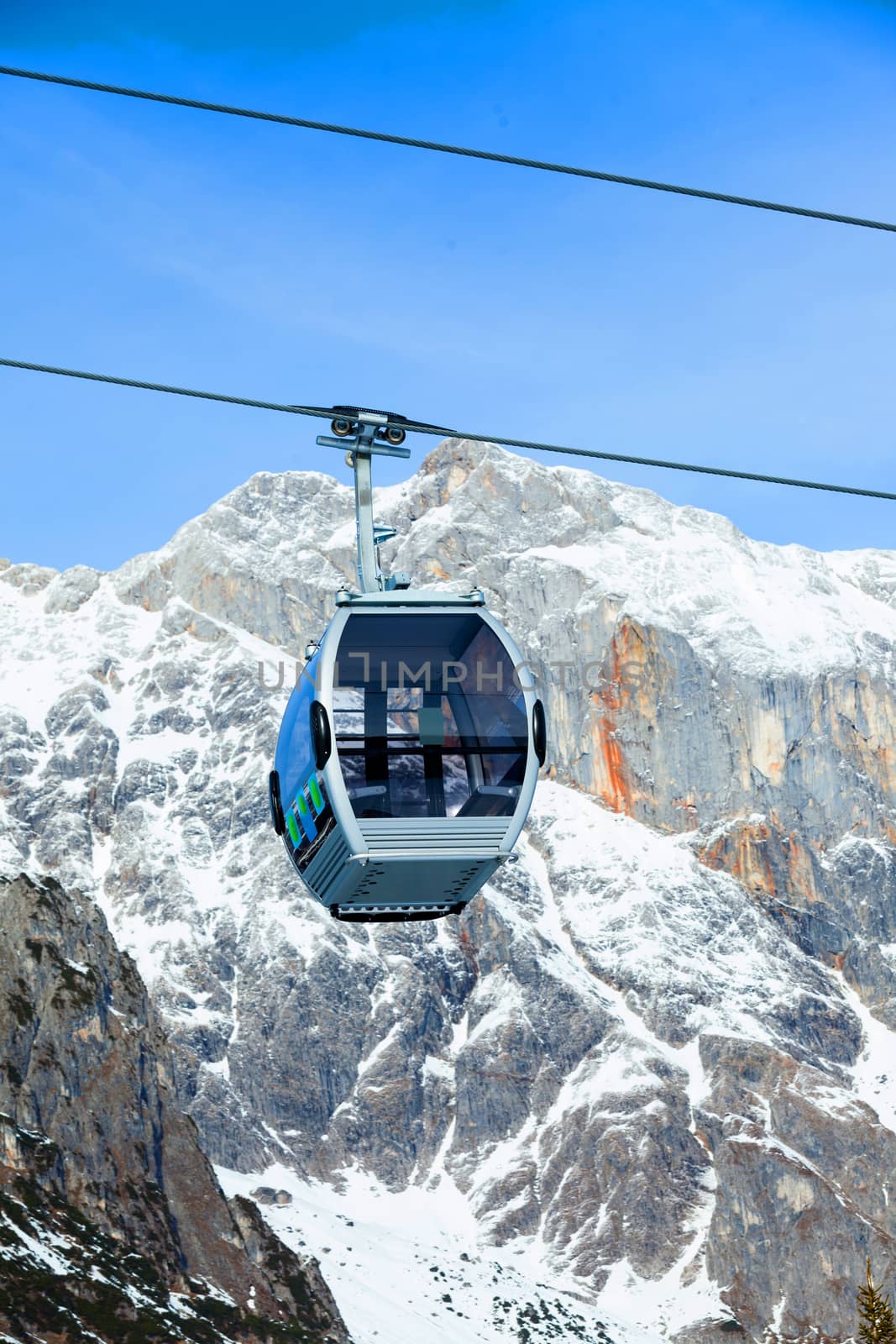 Cable car on the ski resort in Austria. On the background mountain and blue sky.
