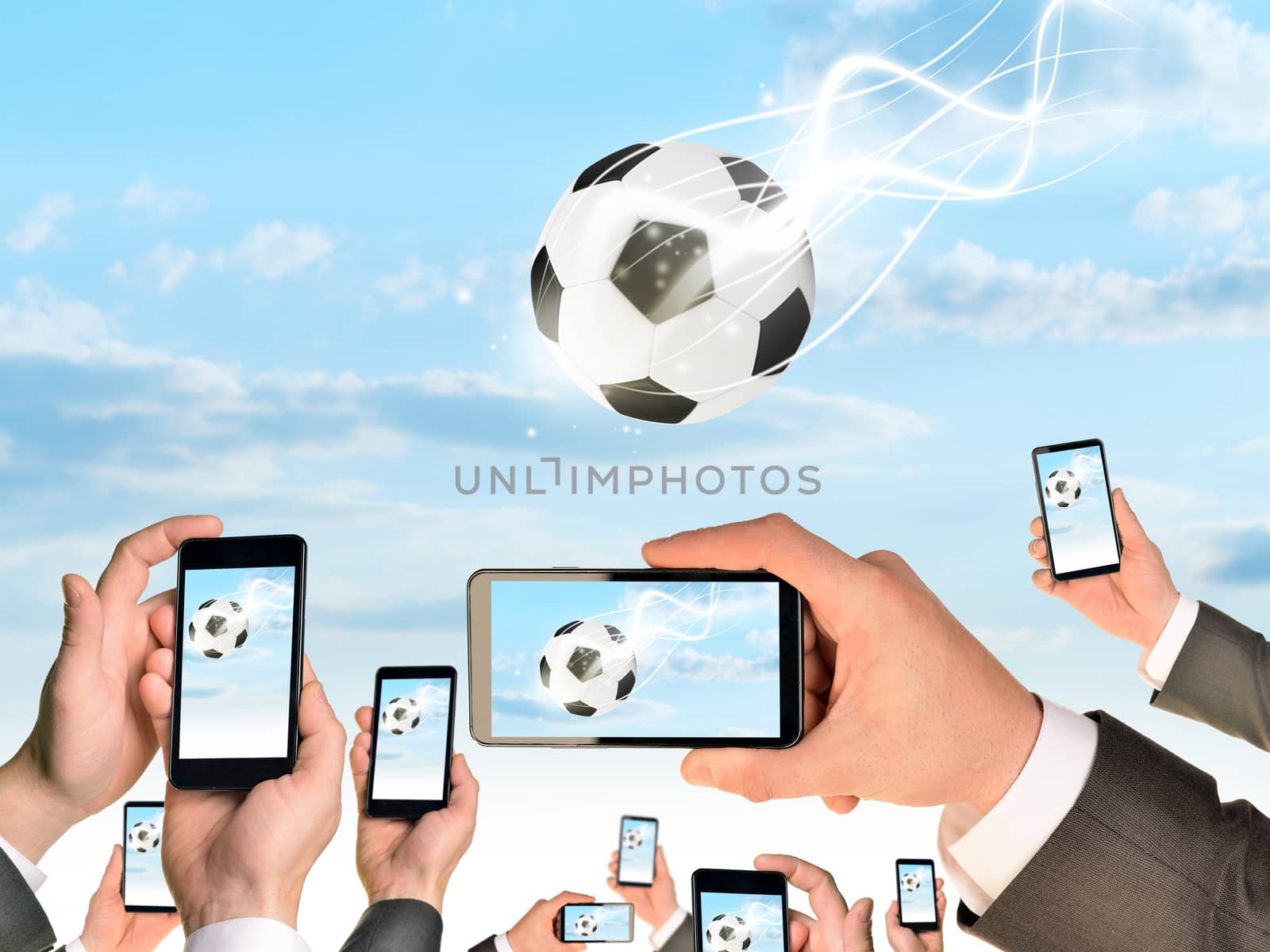 Hands holding smart phones and shoot video as falling soccer ball. Sky with clouds on background