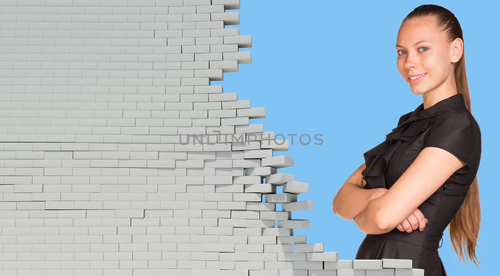Beautiful businesswoman in dress smiling and looking at camera. Dilapidated brick wall as backdrop by cherezoff