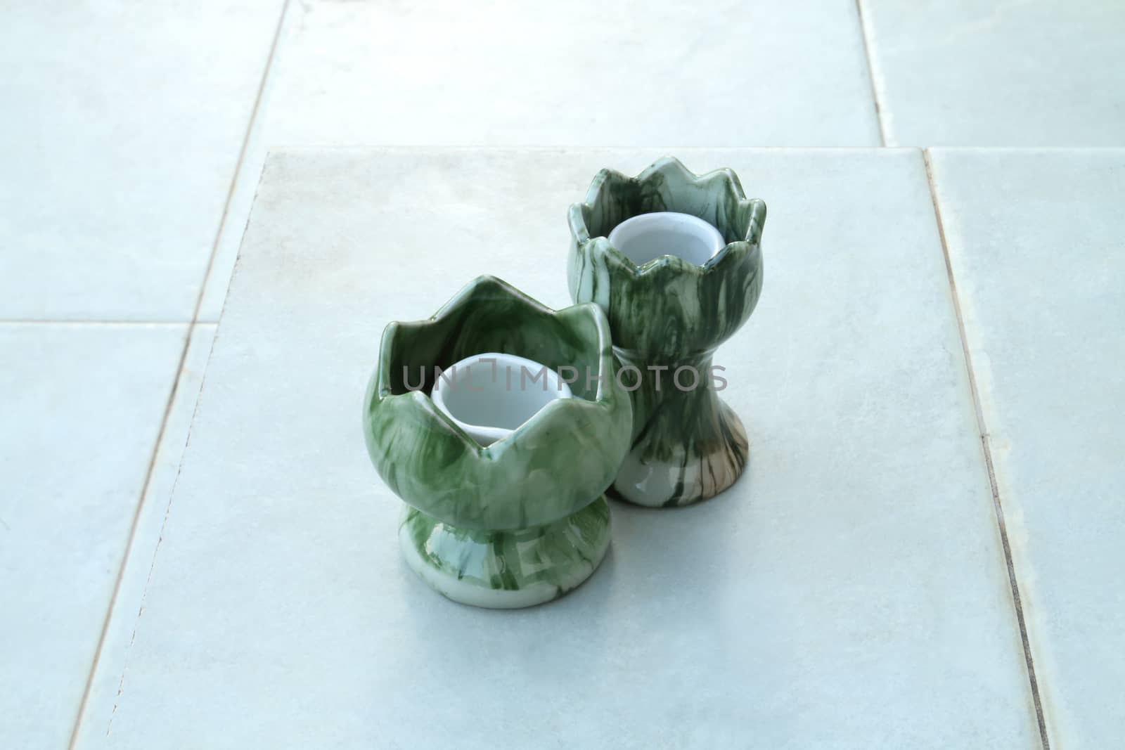 Two of ceramic candlestick on the floor.