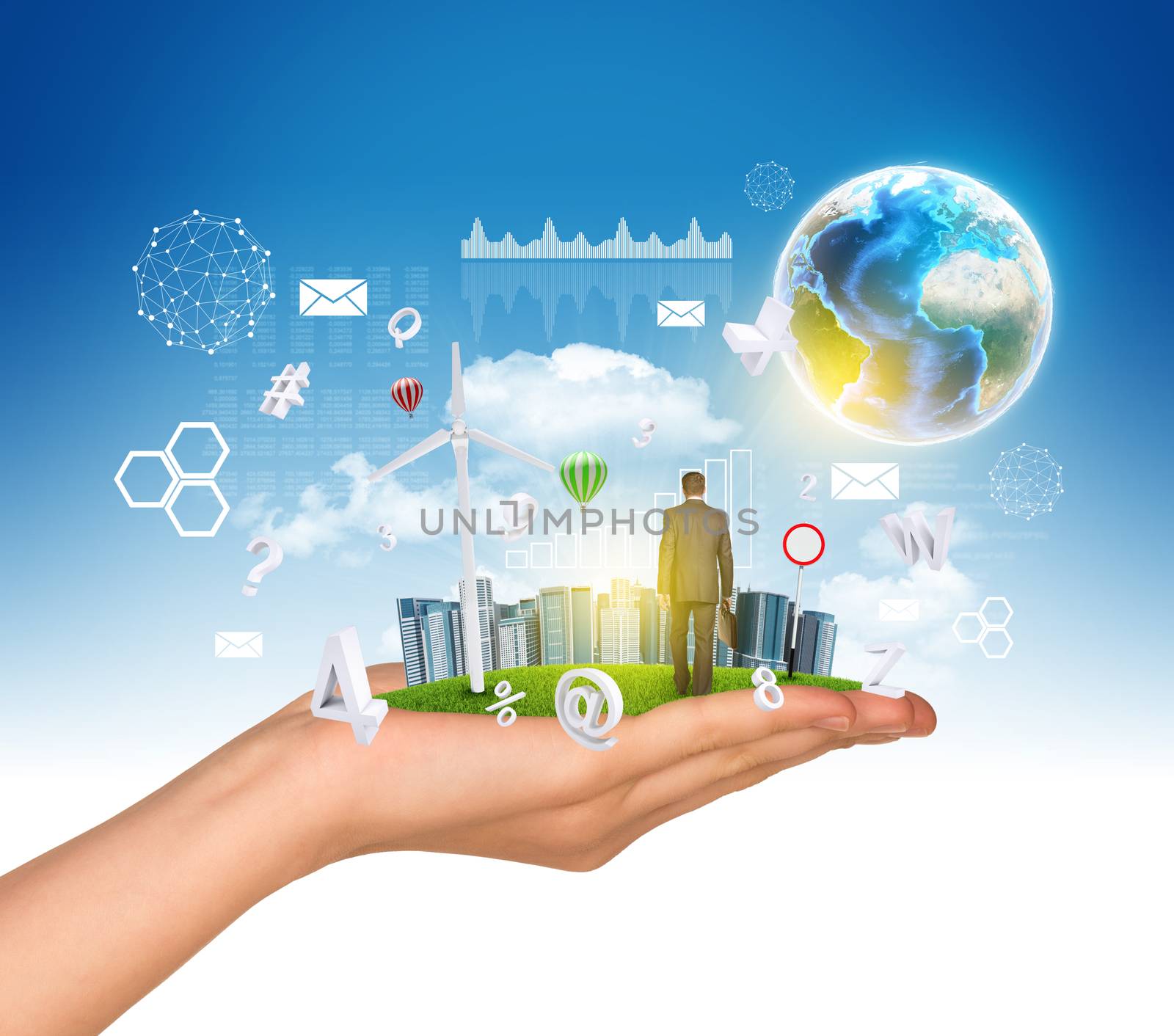 Hand holds city of skyscrapers on green grass and businessman walking forward. Earth and fying letters near hand. Element of this image furnished by NASA