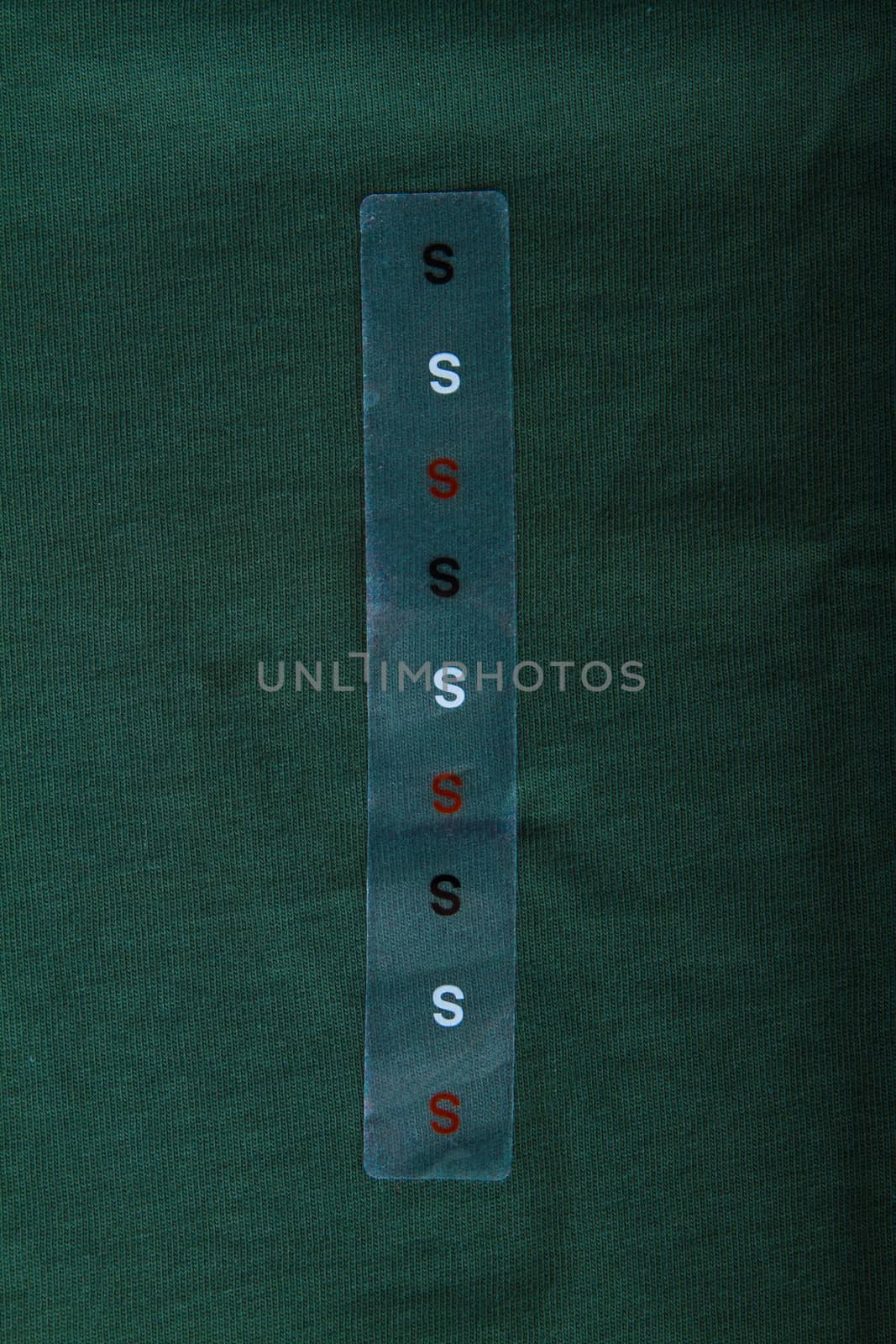 Label size S on green cloth - Stock Image