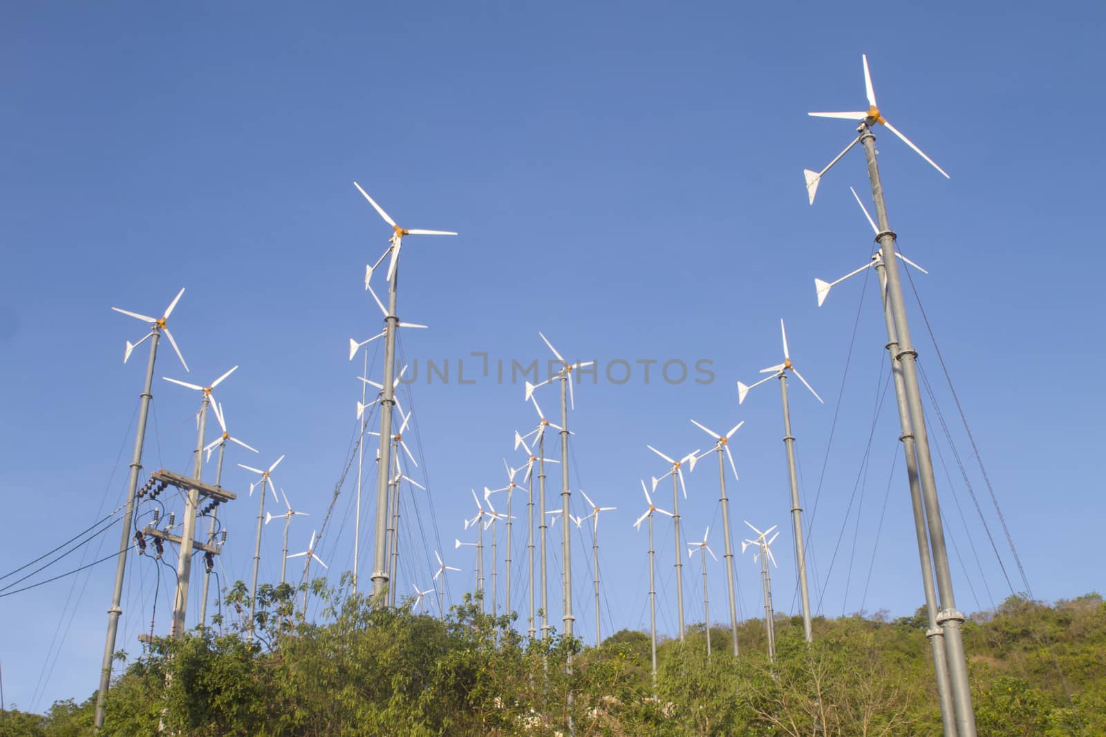 Wind driven generators, turbines over blue sky
