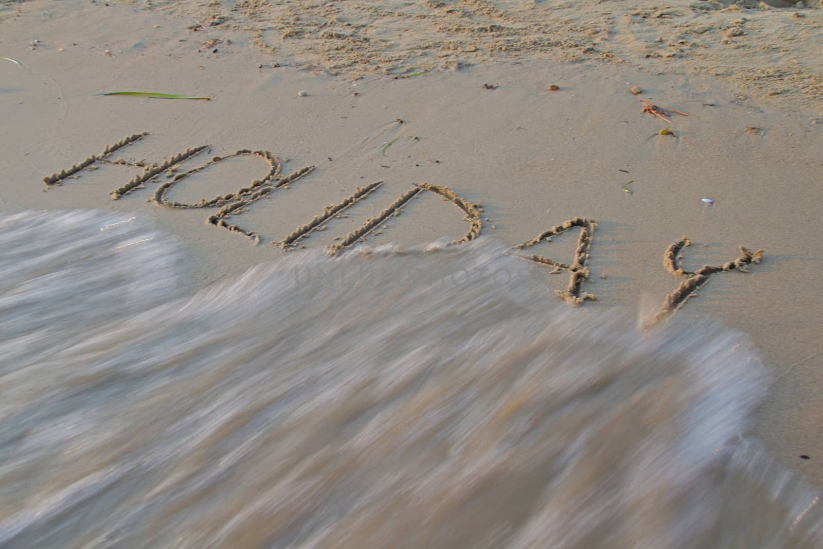 Photo shows a detail of the sign in the beach sand.