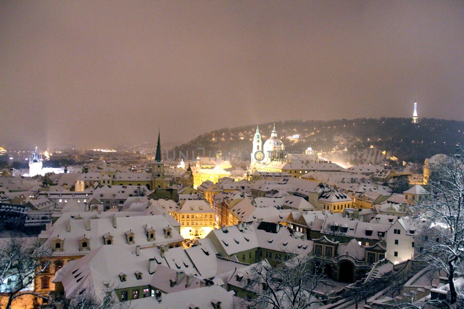 Photo shows Prague at winter night with its houses.