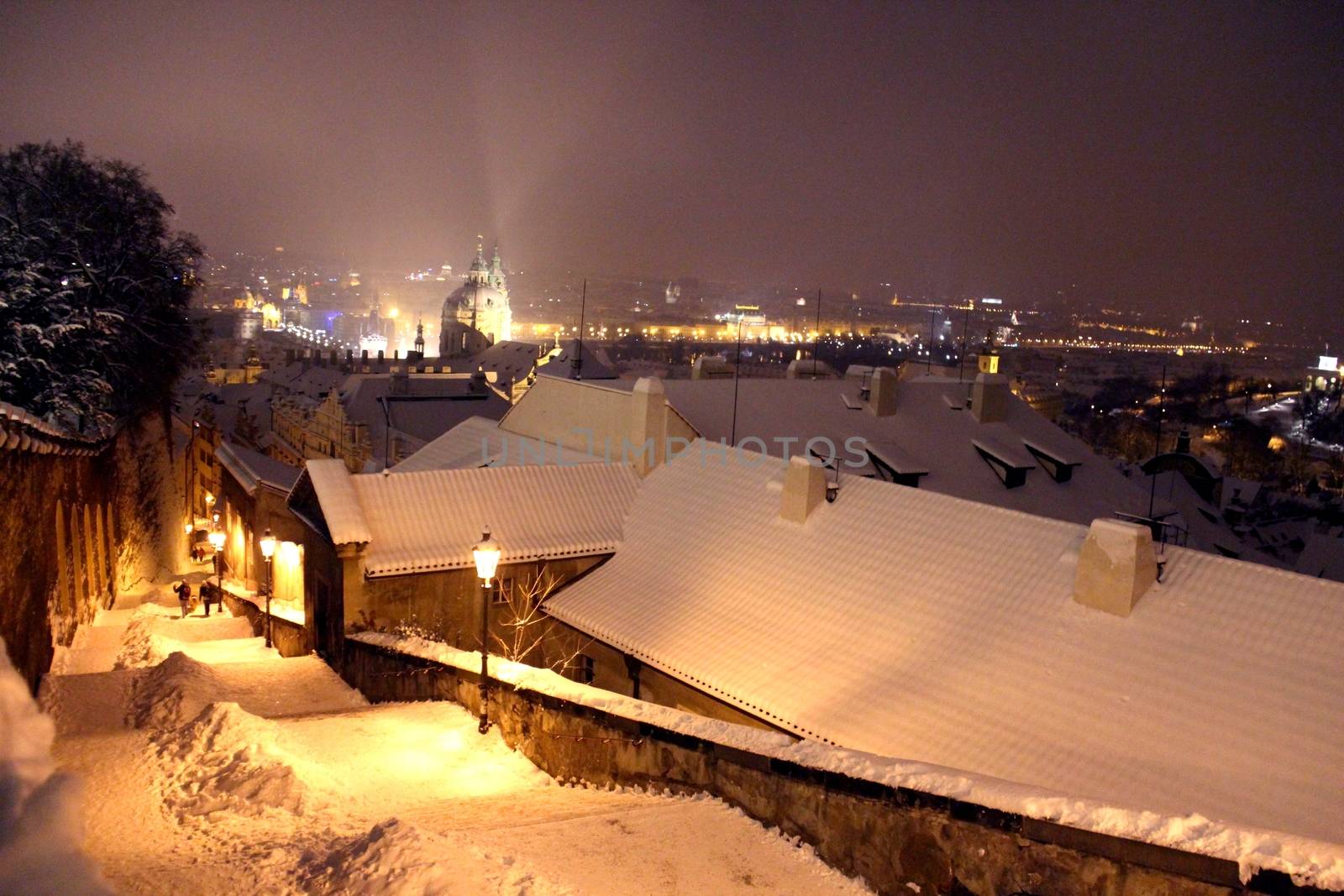 Photo shows Prague at winter night with its houses.