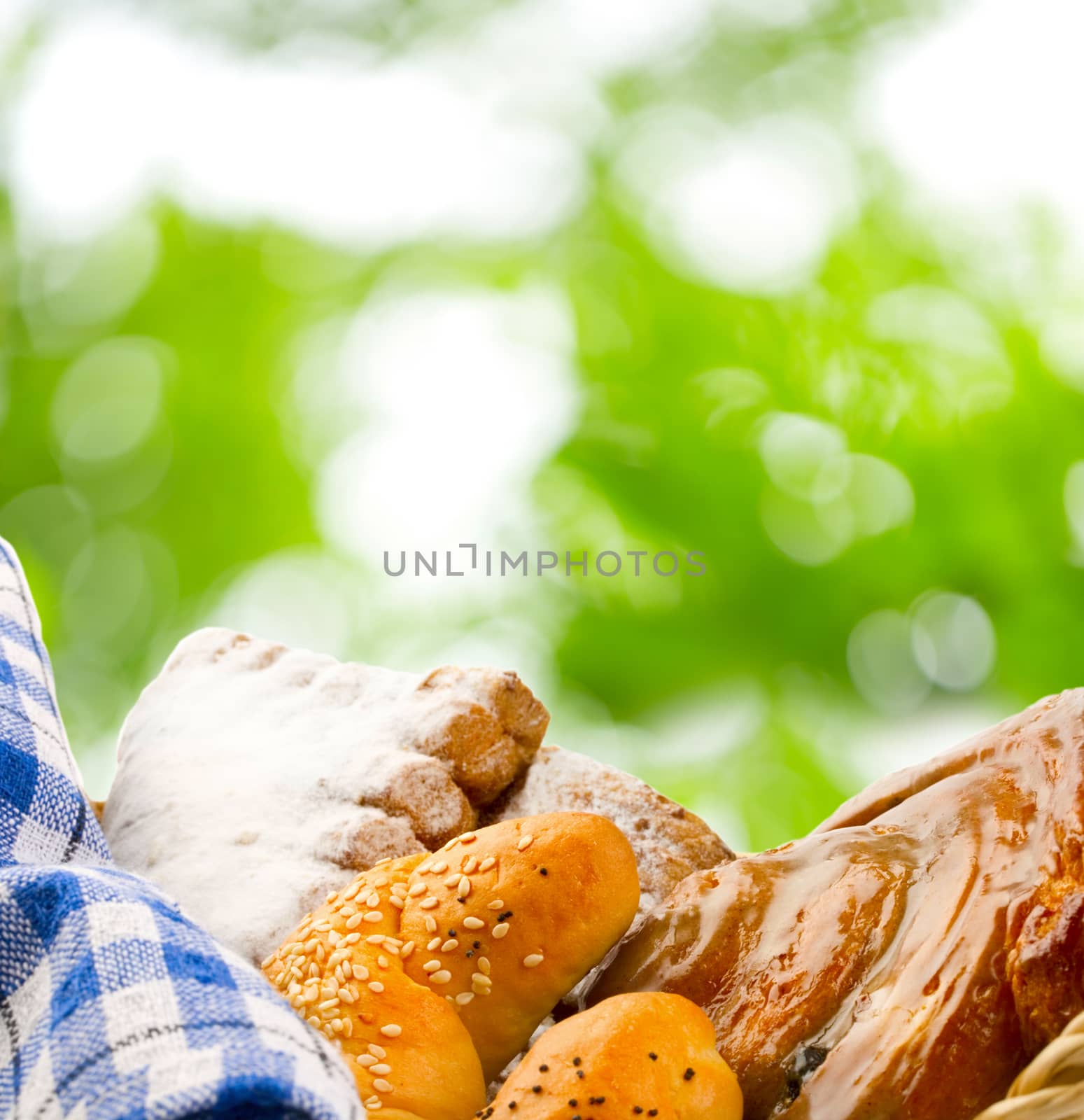 Basket of buns on green leaves background