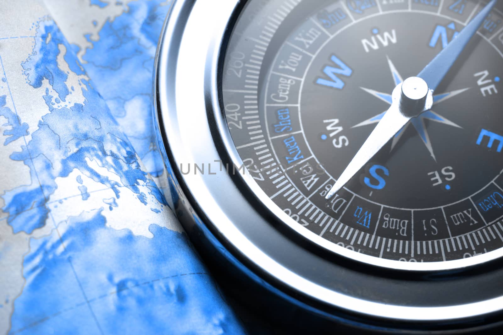 Compass on map background in blue toning