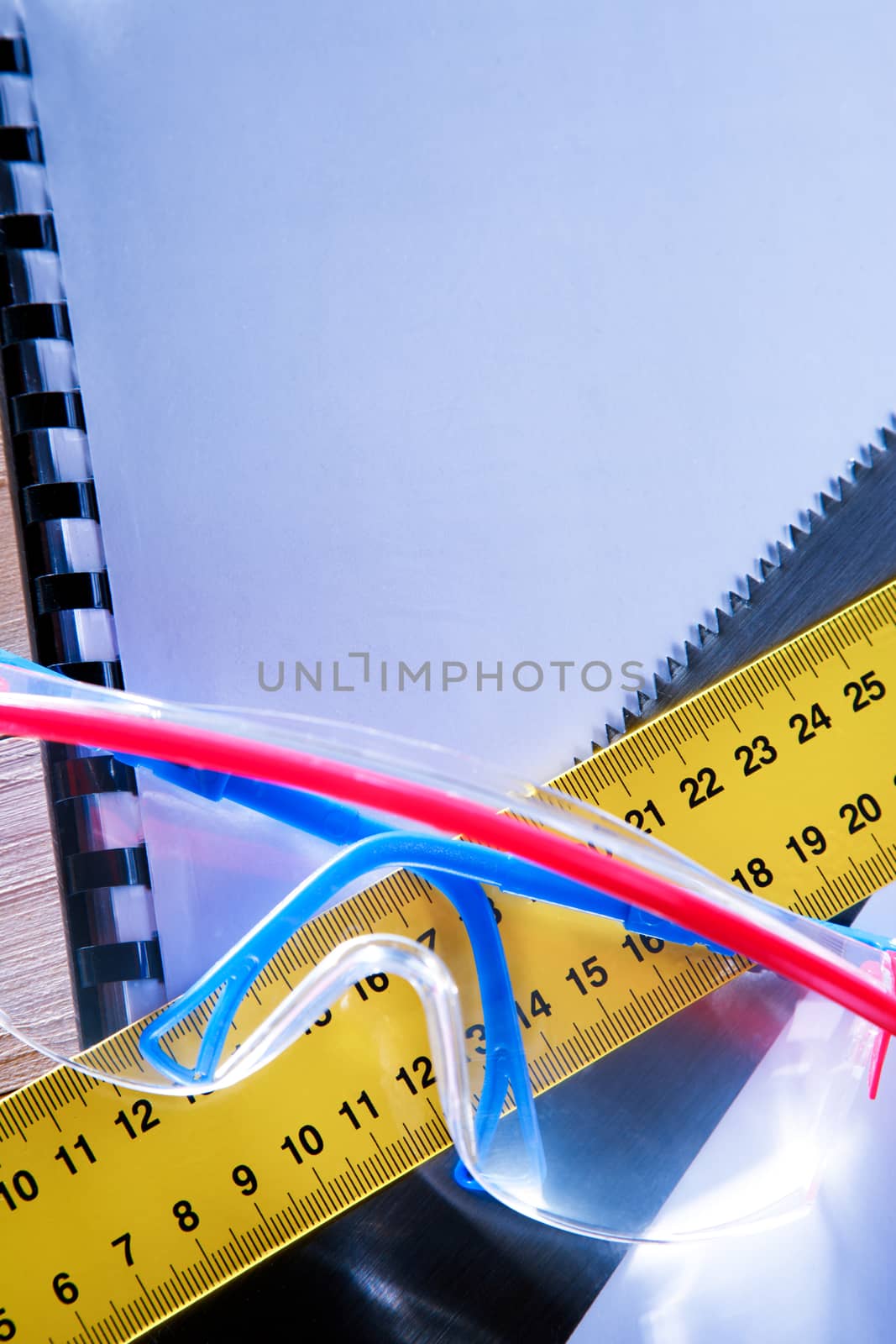 Ruler, notebook, handsaw and goggles