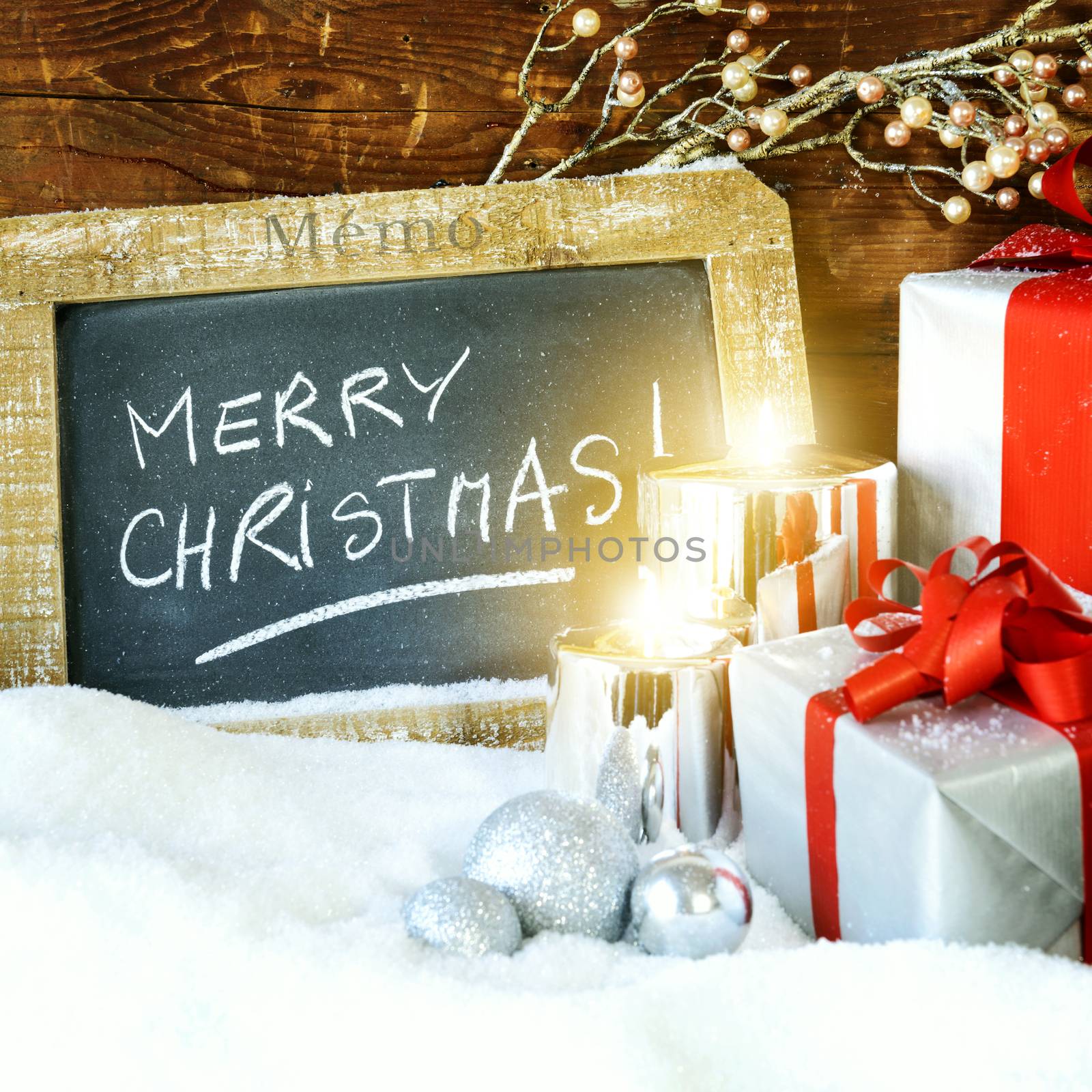 Closeup of Christmas gifts with candle and slate. 