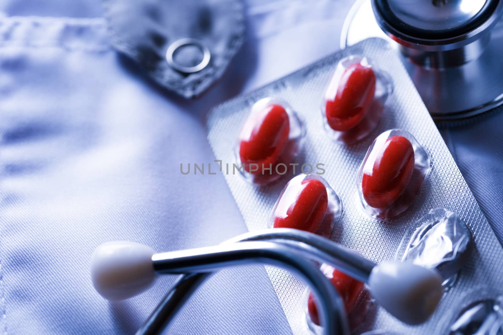 Stethoscope and pills and on doctor's smock