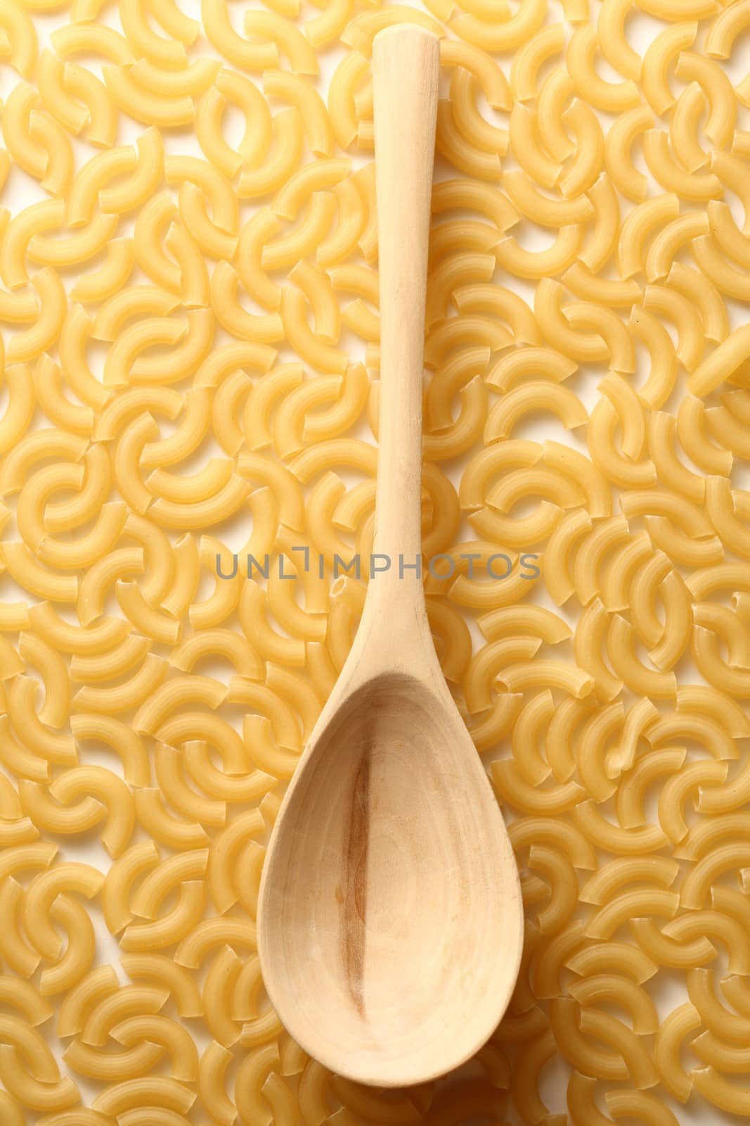 Short ribbed pasta tubes background with spoon