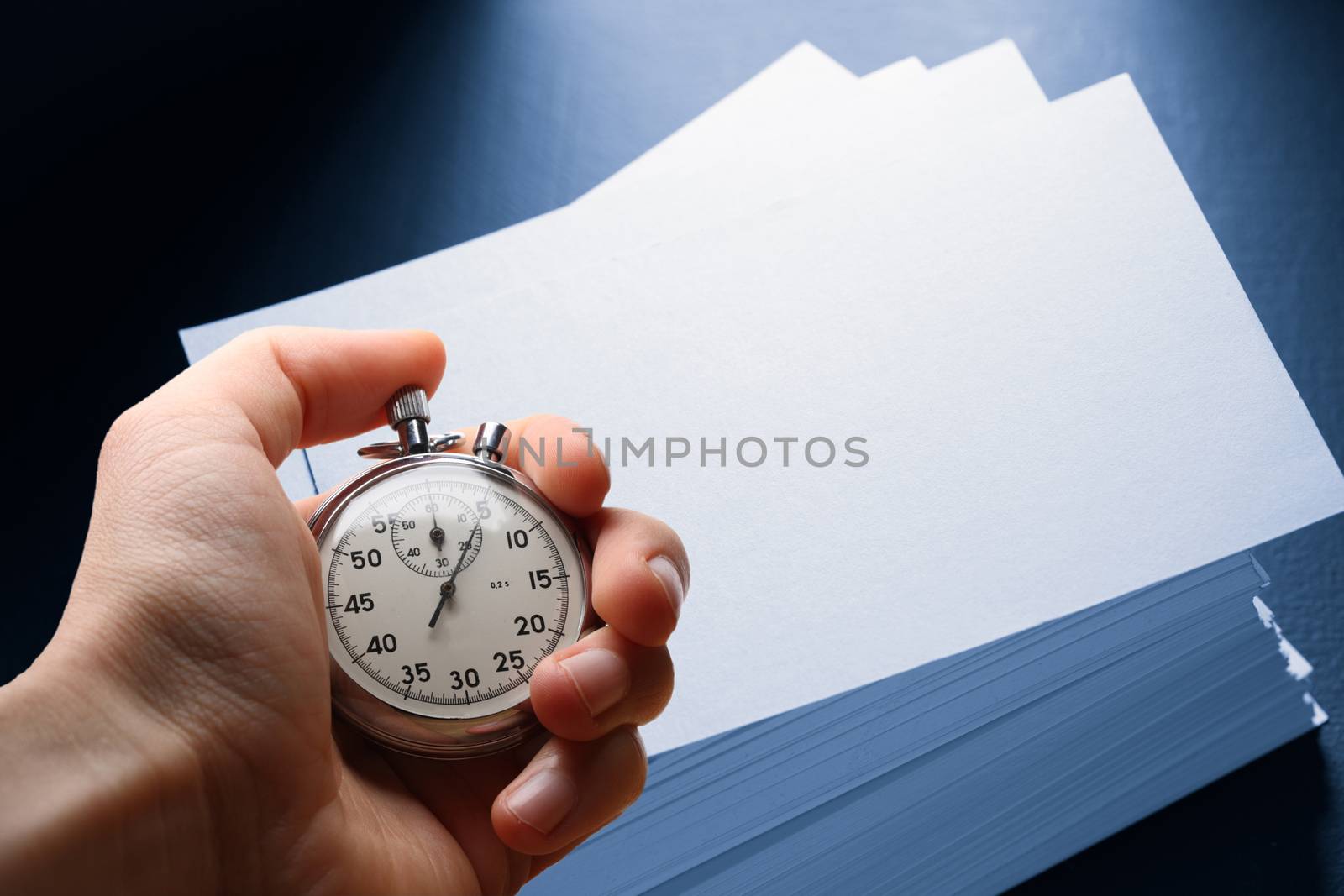 Paper cards on black and hand with stopwatch