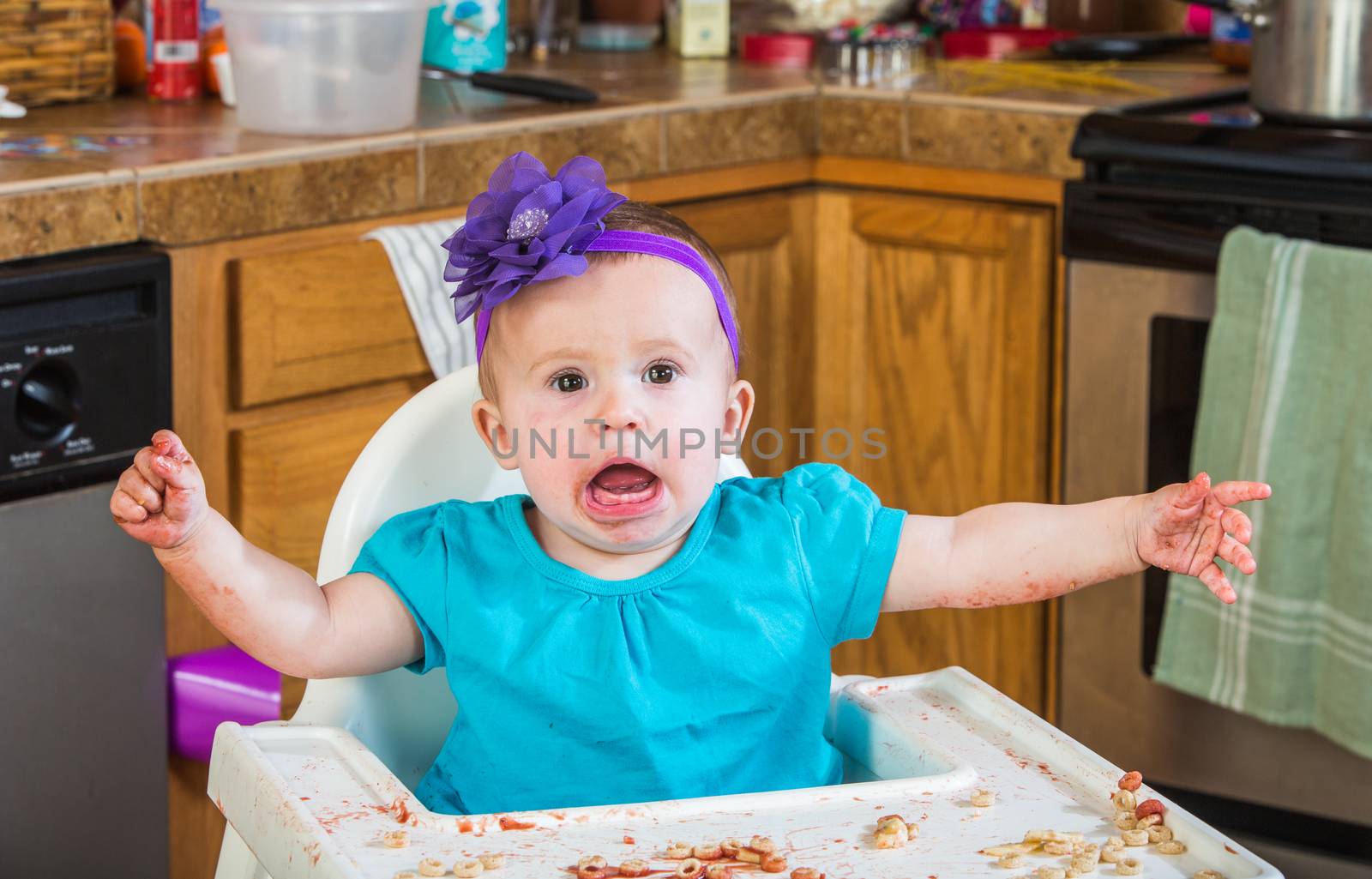A talkative baby girl eating in the kitchen