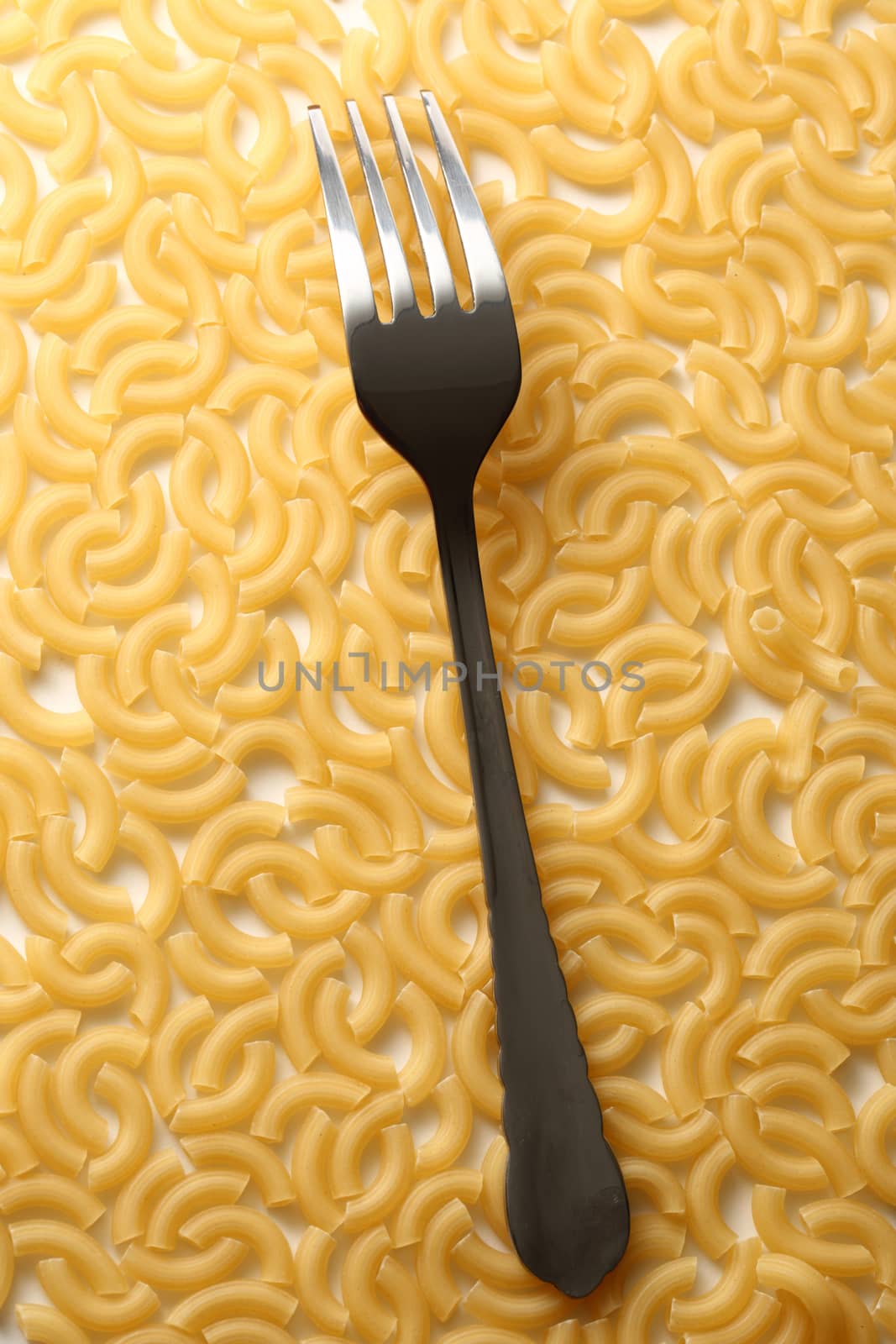 Short ribbed pasta tubes background with fork