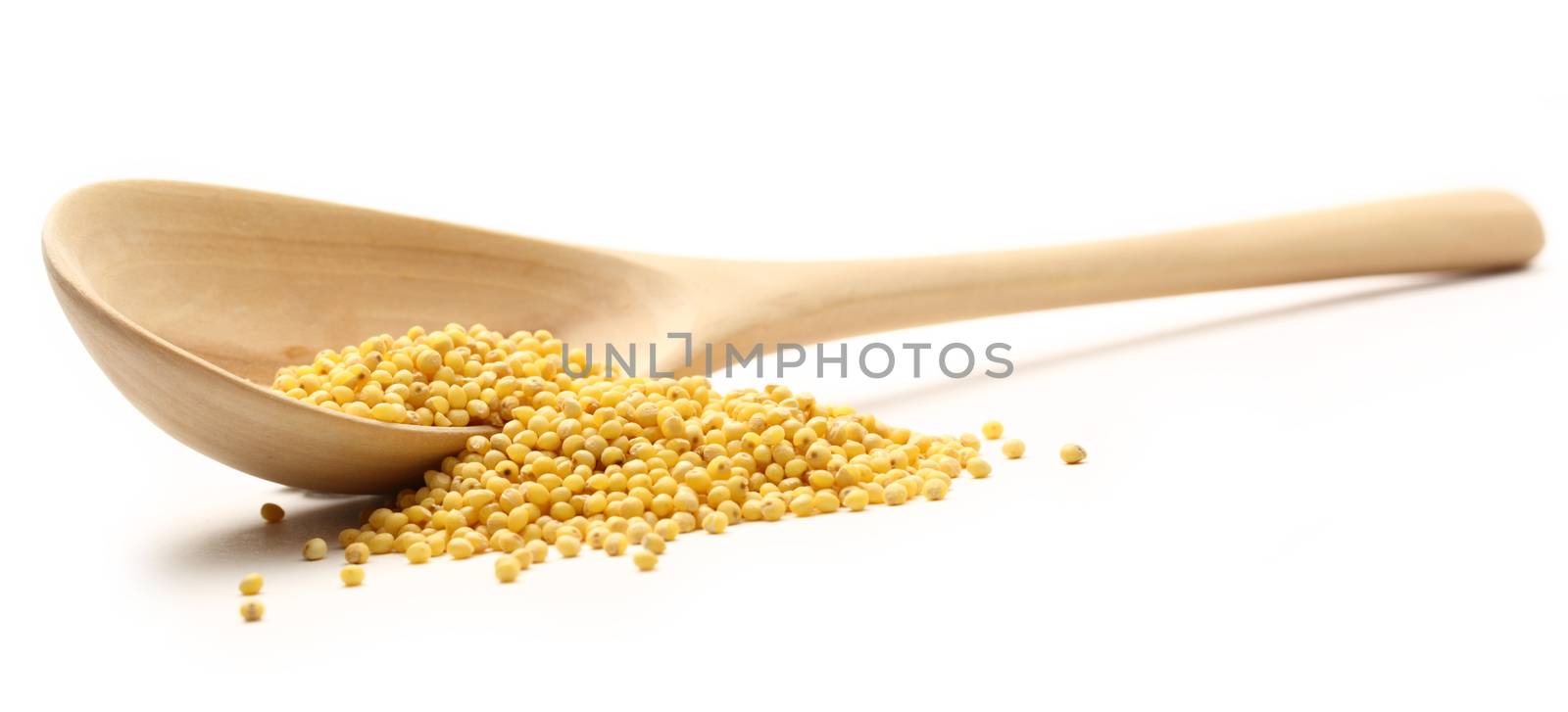 Millet groats with wooden spoon on white