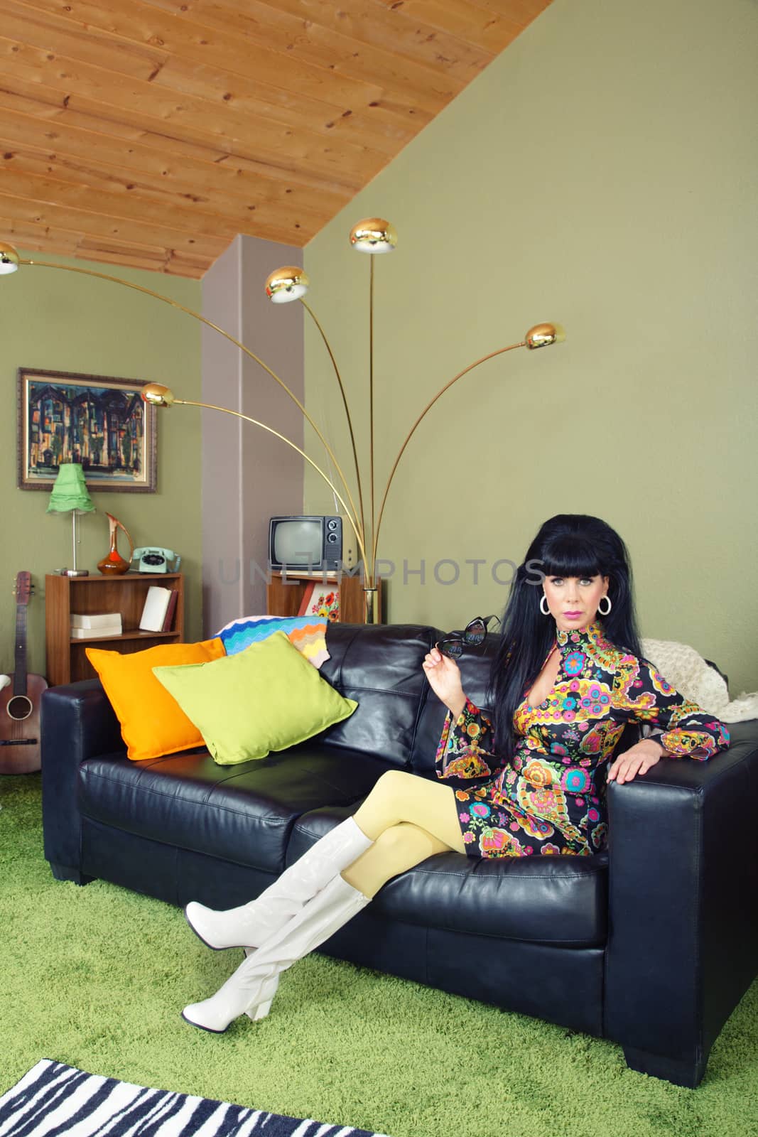 Laid back pretty retro woman sitting on leather sofa