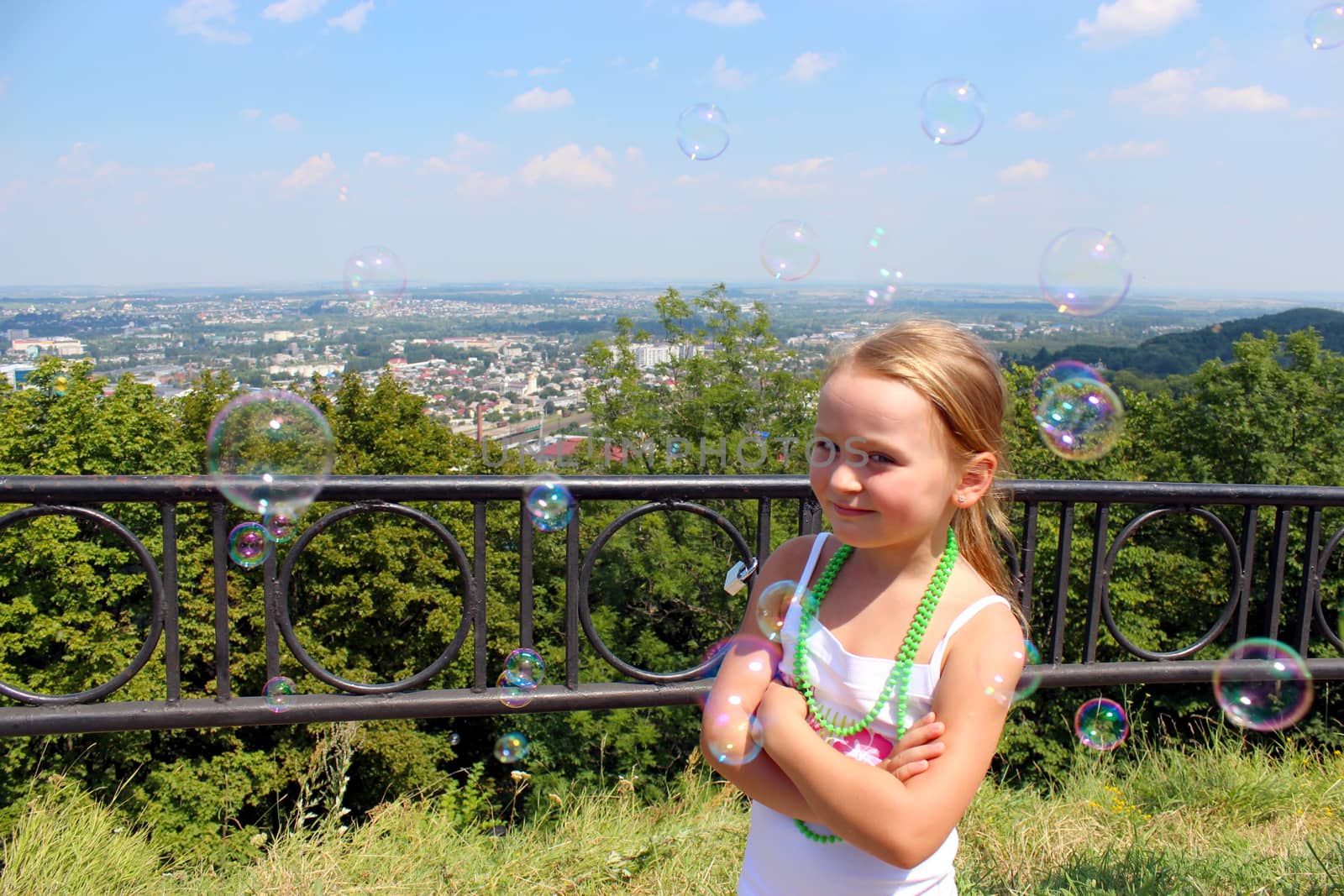 little girl with soap bubbles out of city by alexmak