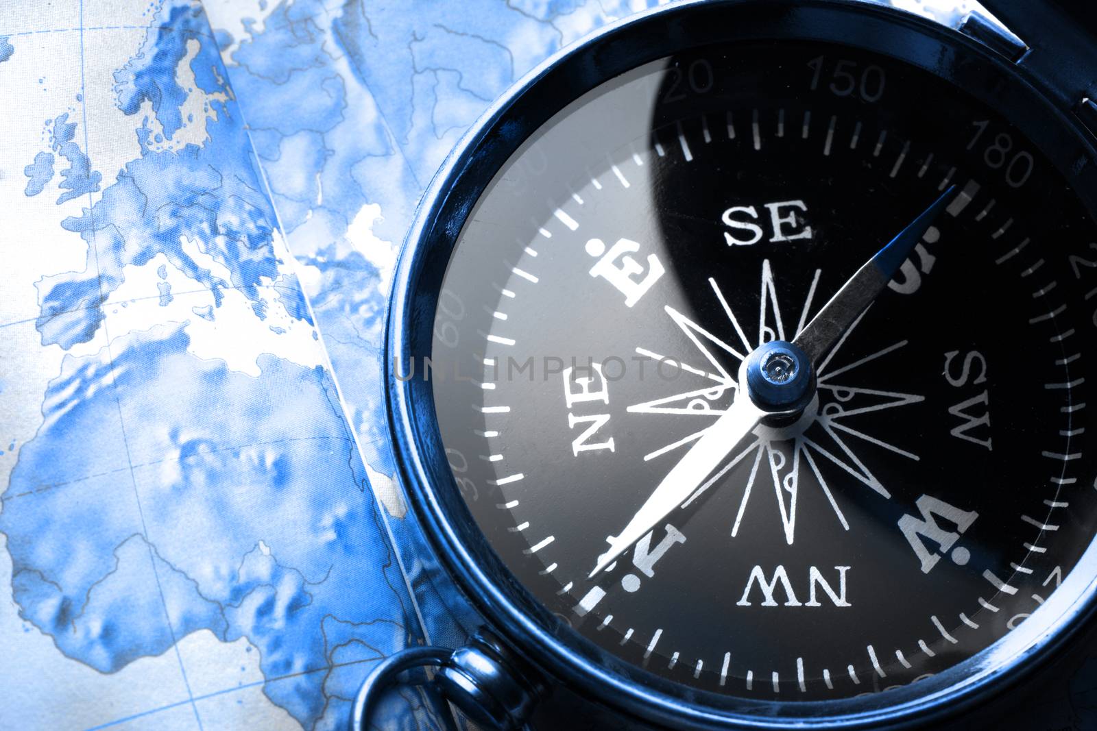 Compass on map background in blue toning