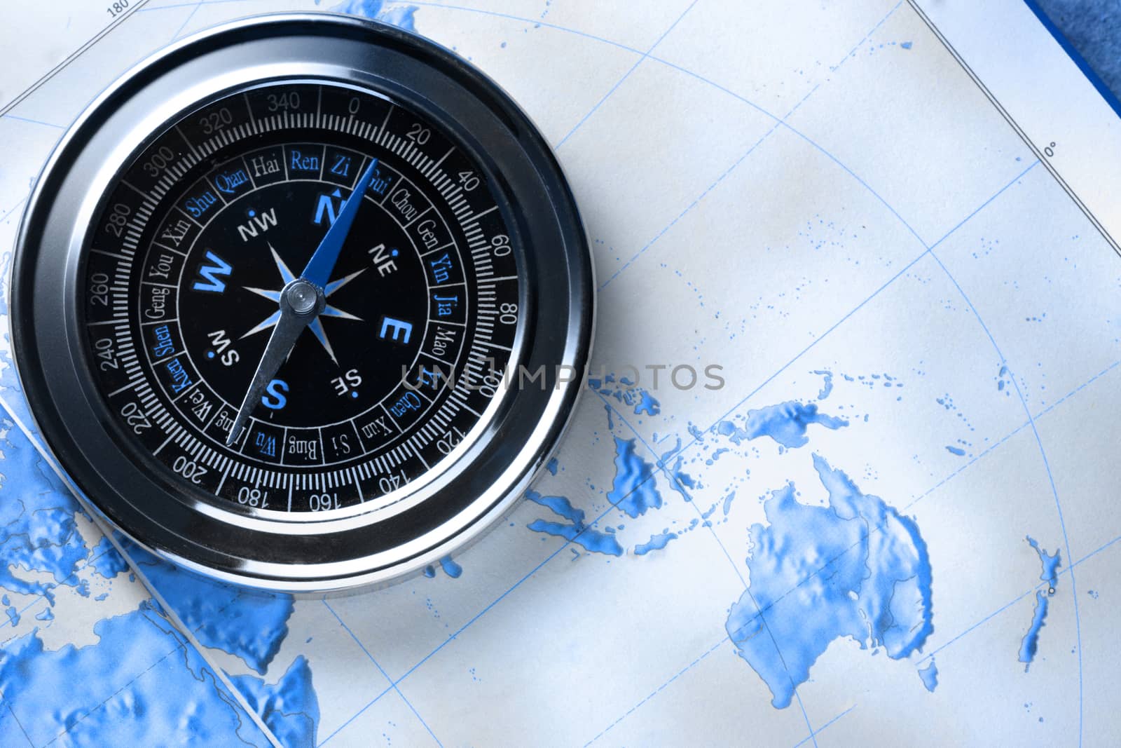 Compass on map background in blue toning